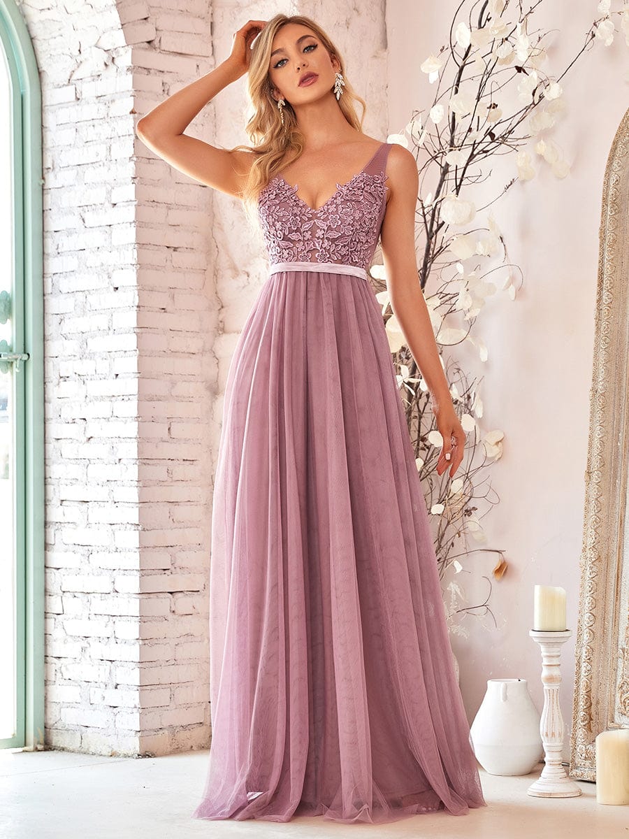 Model wearing a dark blue A-line V-neck floral lace bridesmaid dress.