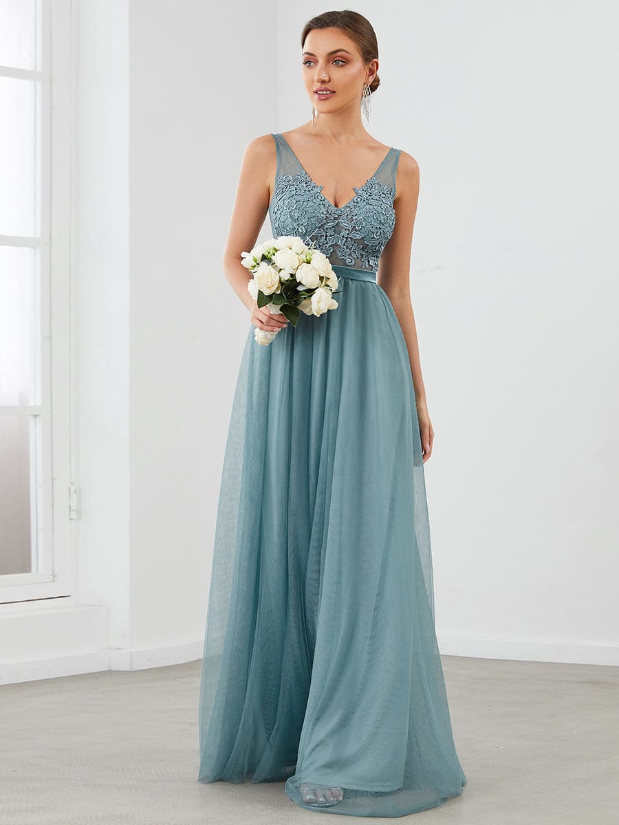 Model wearing a dark green A-line V-neck floral lace bridesmaid dress.