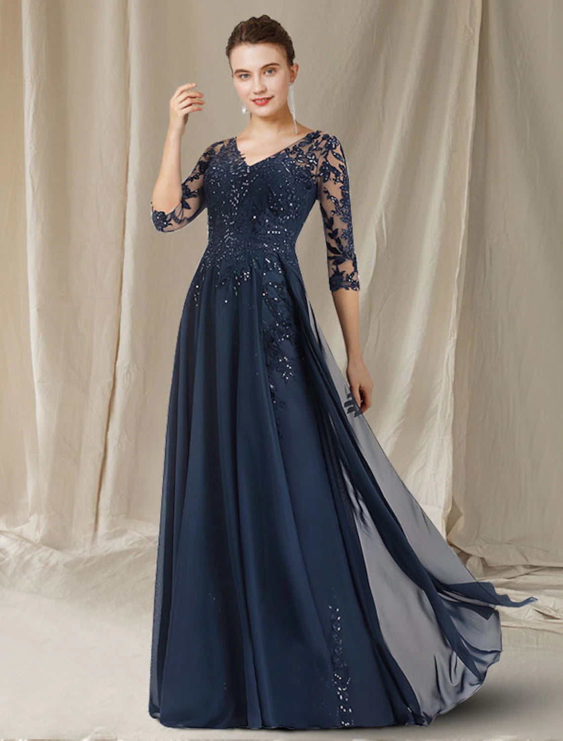Elegant woman in a light blue A-line V-neck half-sleeve Mother of the Bride dress with lace and sequins.