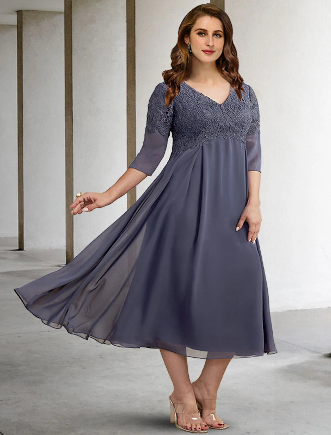 Woman wearing an elegant A-line V-neck half-sleeve tea-length chiffon dress with appliques.