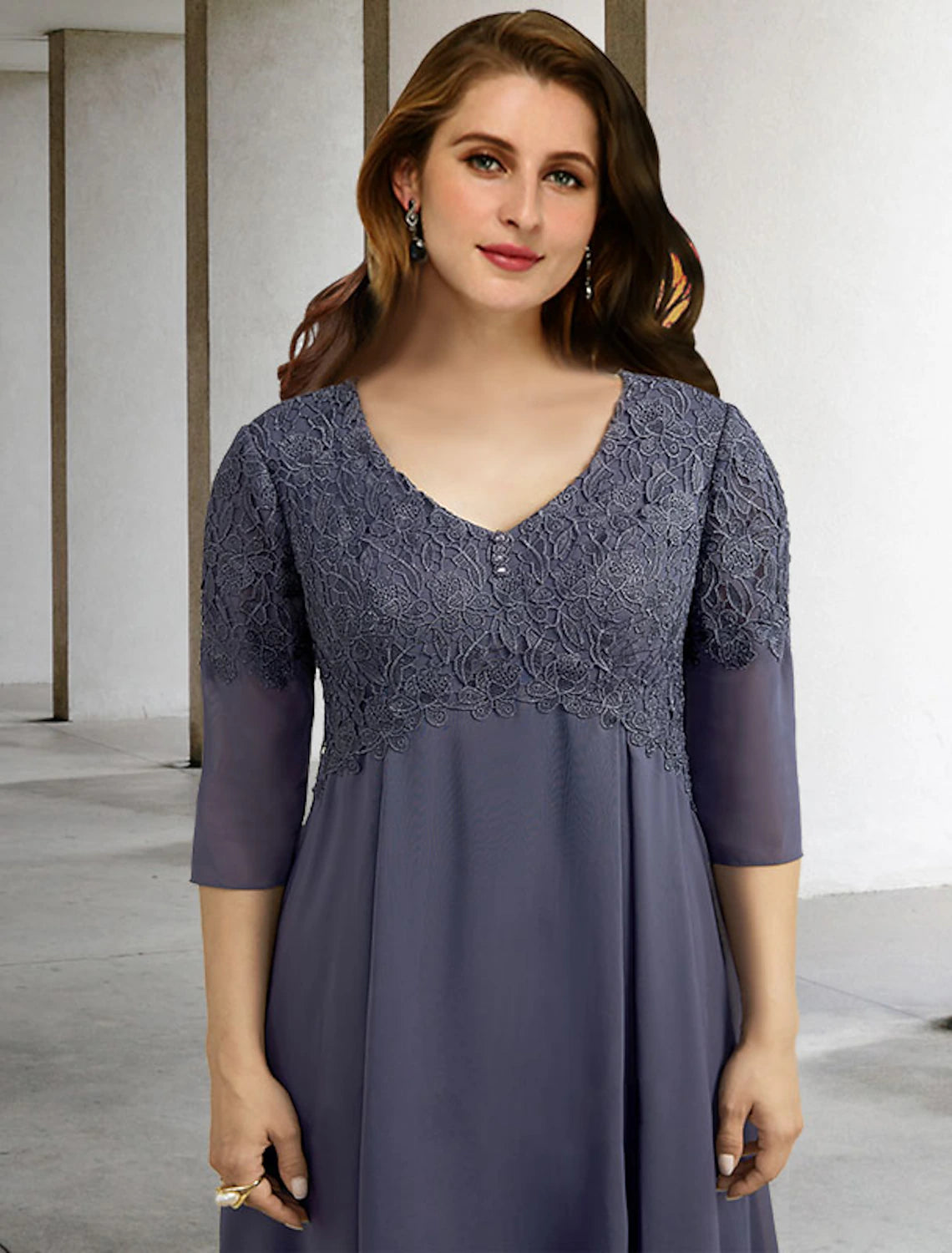 Woman posing in the elegant A-line mother of the bride dress, showcasing its flow.