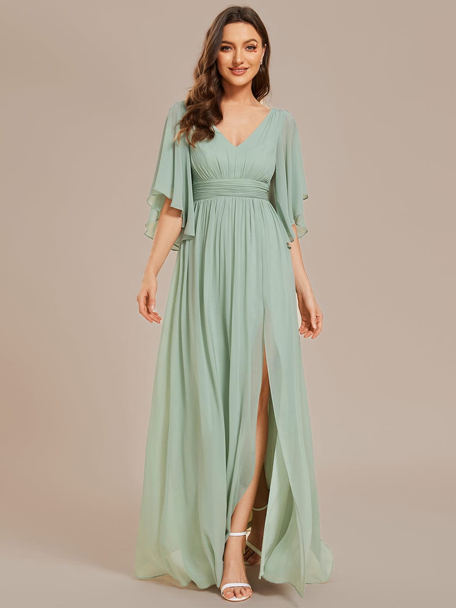 Model wearing a green A-line V-neck half-sleeve pleated chiffon bridesmaid dress with a high slit, front view.