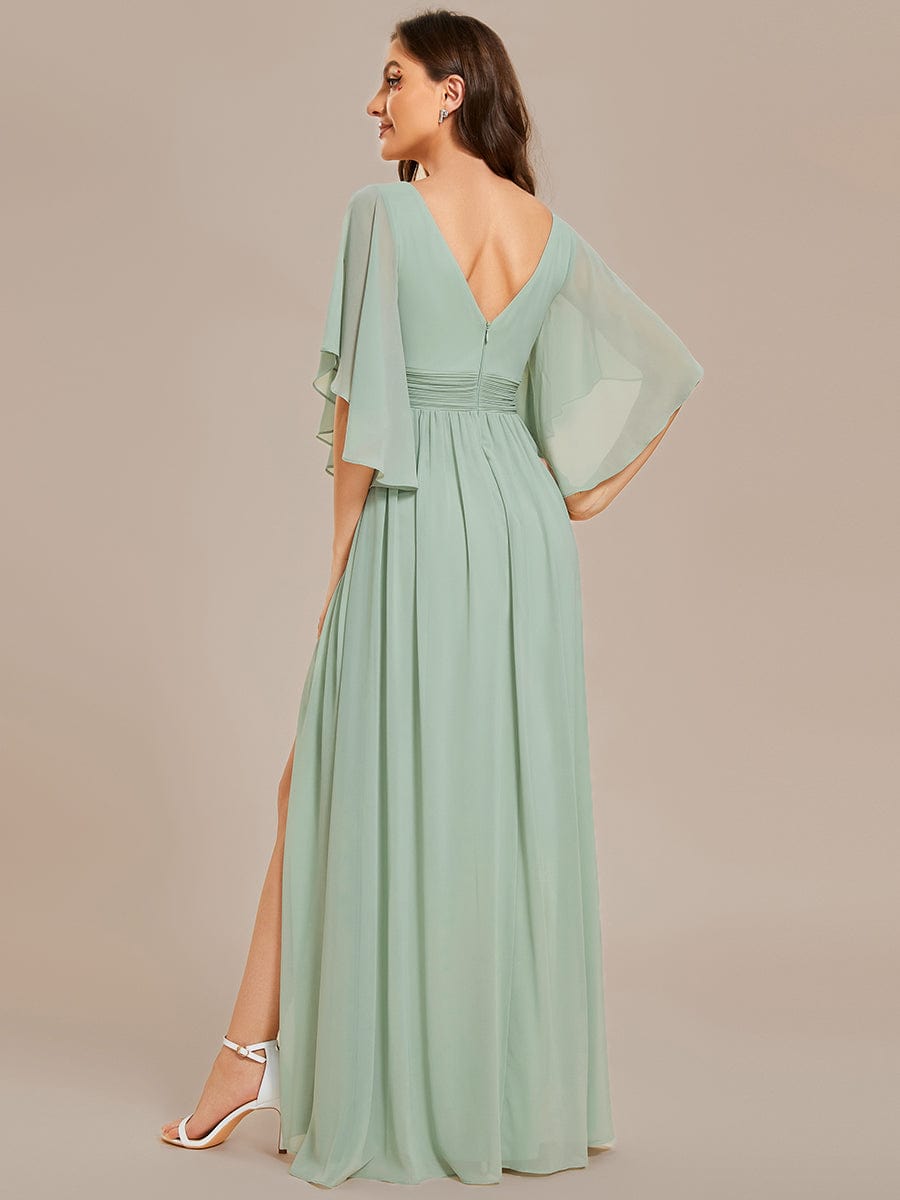 Model wearing a green A-line V-neck half-sleeve pleated chiffon bridesmaid dress with a high slit, back view.