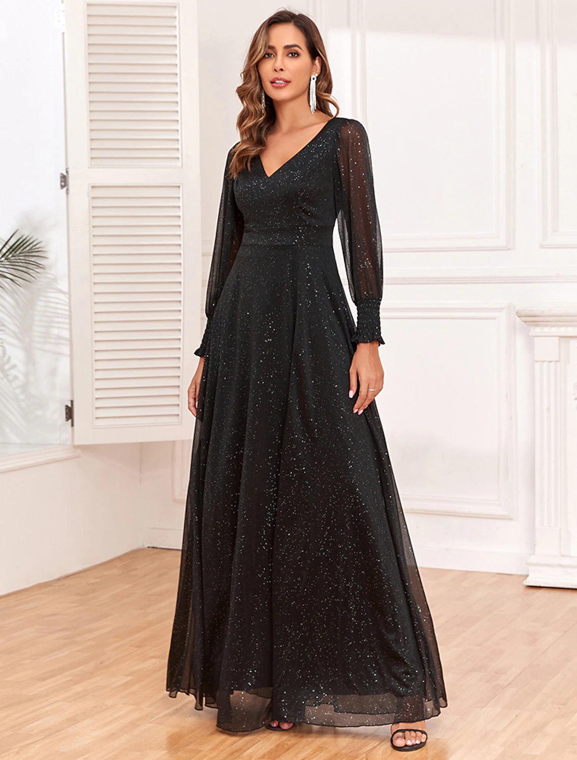 Back view of a black A-line tulle gown, highlighting the V-back design and floor-length skirt.