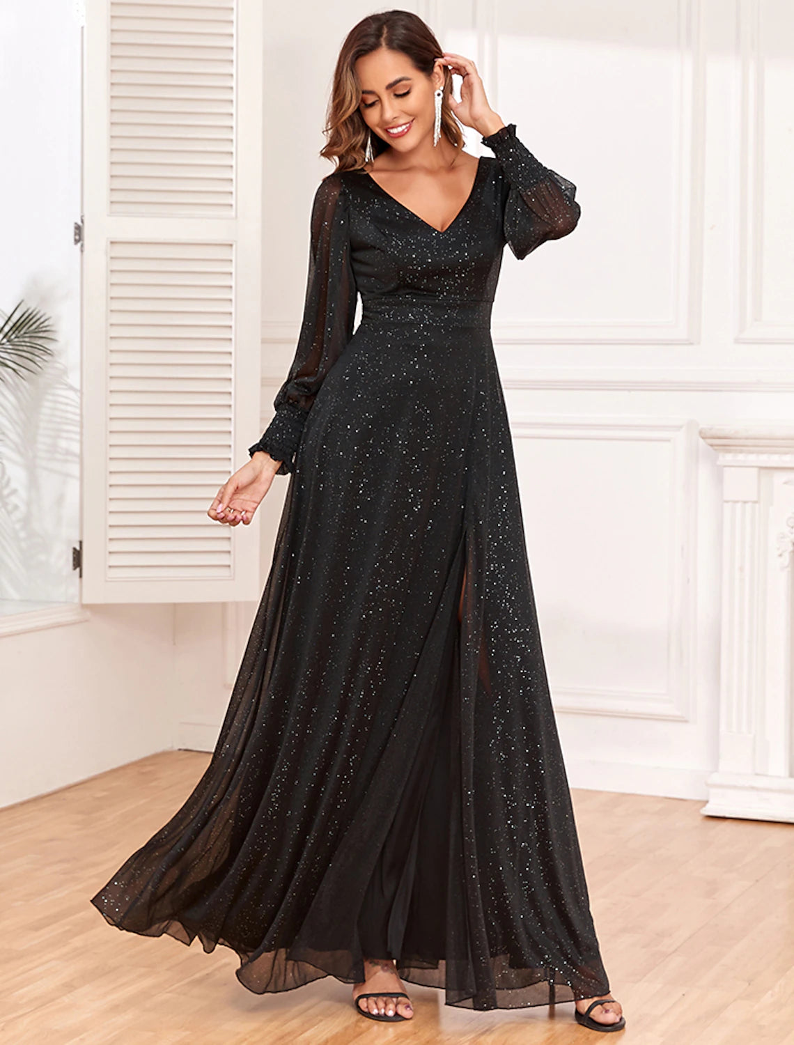 Model posing in a black A-line long sleeve V-neck evening gown, displaying the full silhouette.