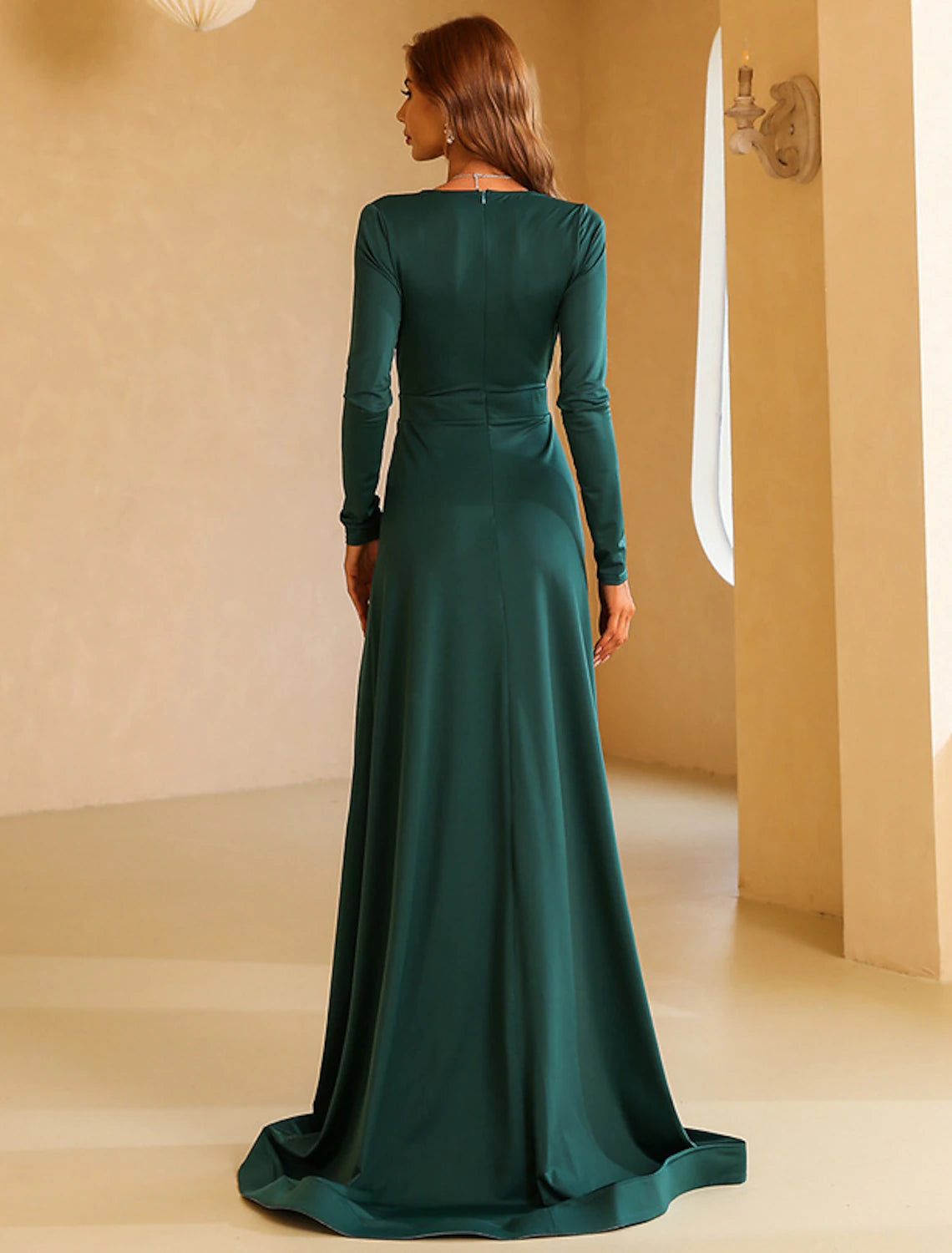 Side view of the A-line long sleeve V-neck gown, showing the elegant silhouette and slit.