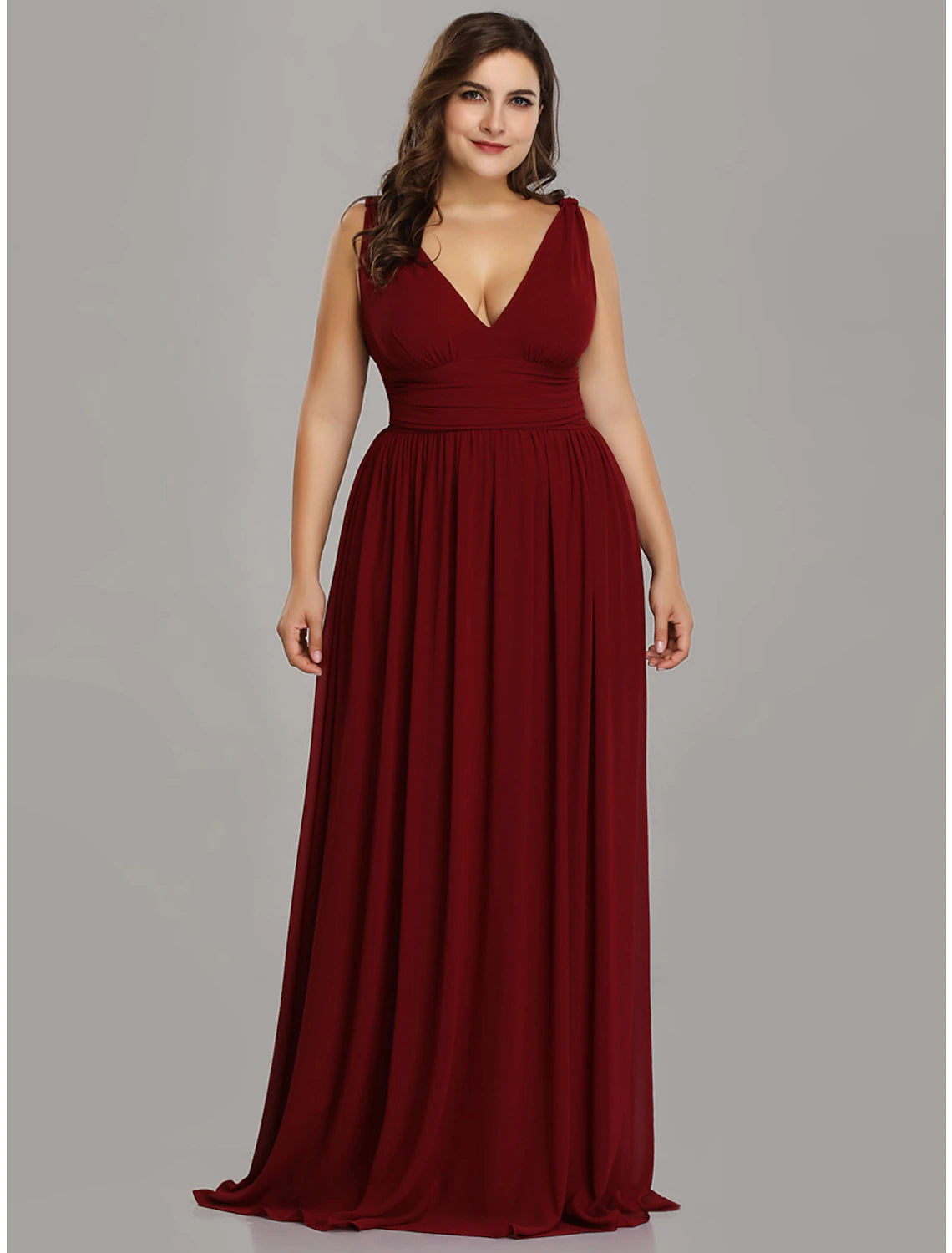 Woman in a flowing A-line V-neck chiffon evening dress with pleats.