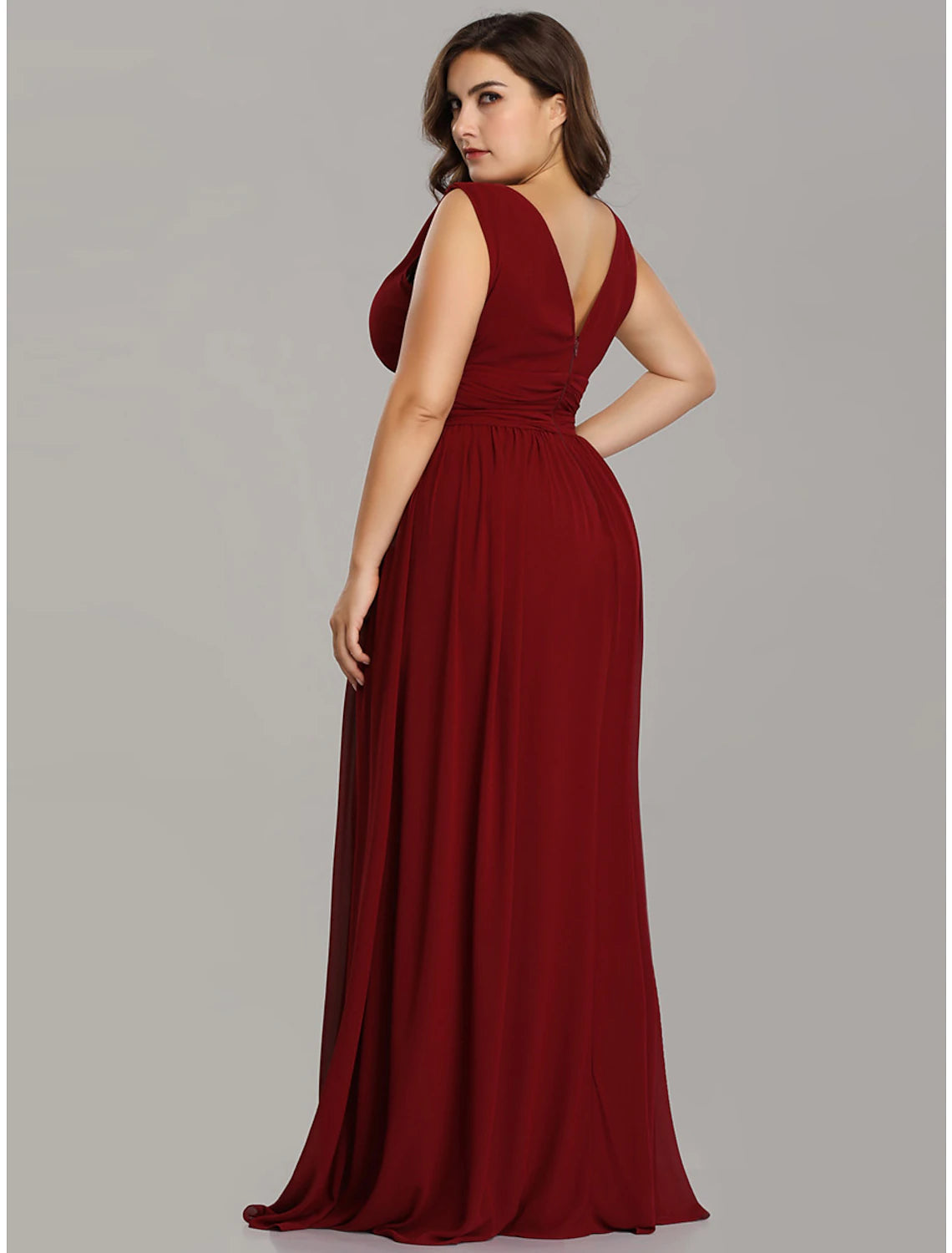 Back view of a woman wearing a sleeveless V-back formal dress.