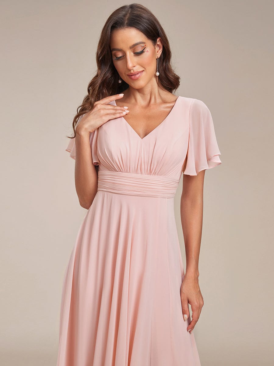 Close-up of ruffle sleeve and V-neck on pink chiffon dress.