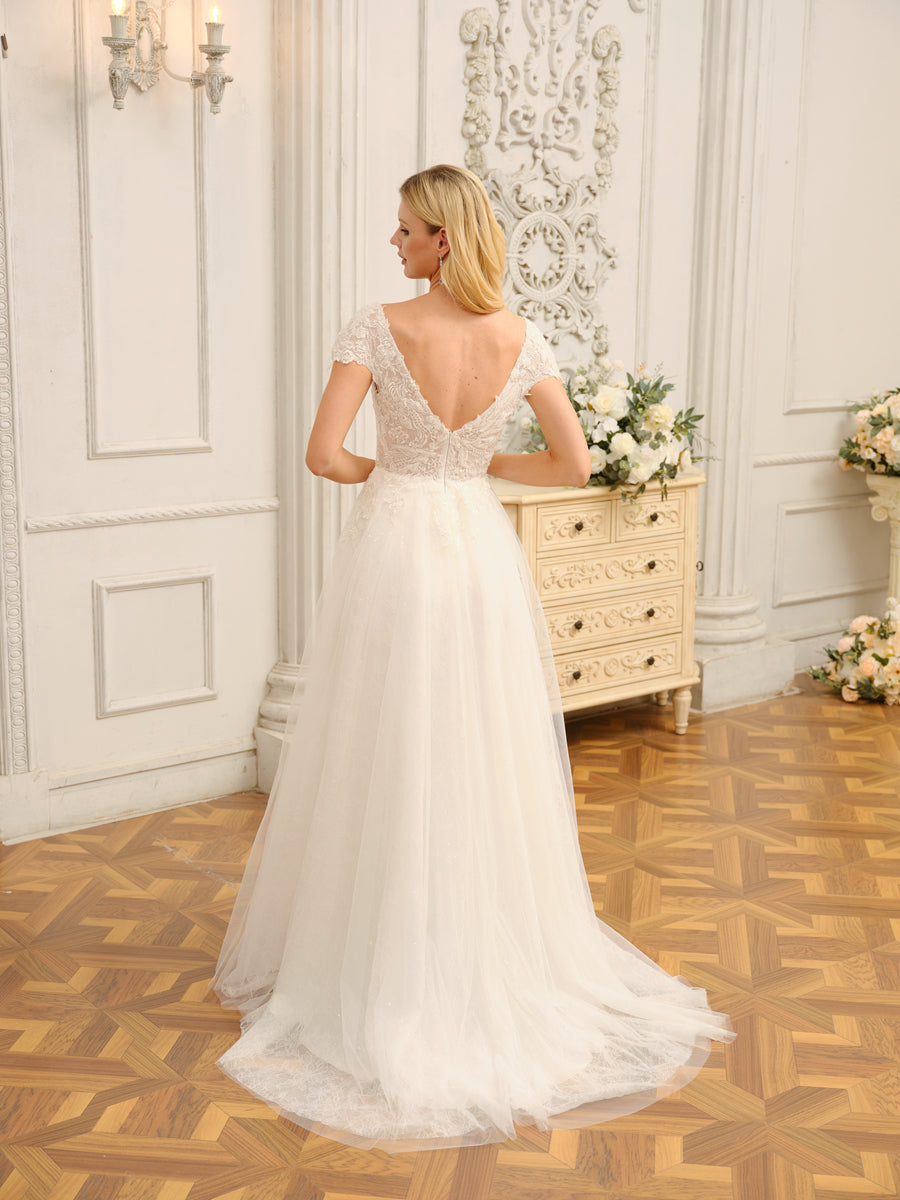 Back view of the long wedding dress, showcasing appliques and train.