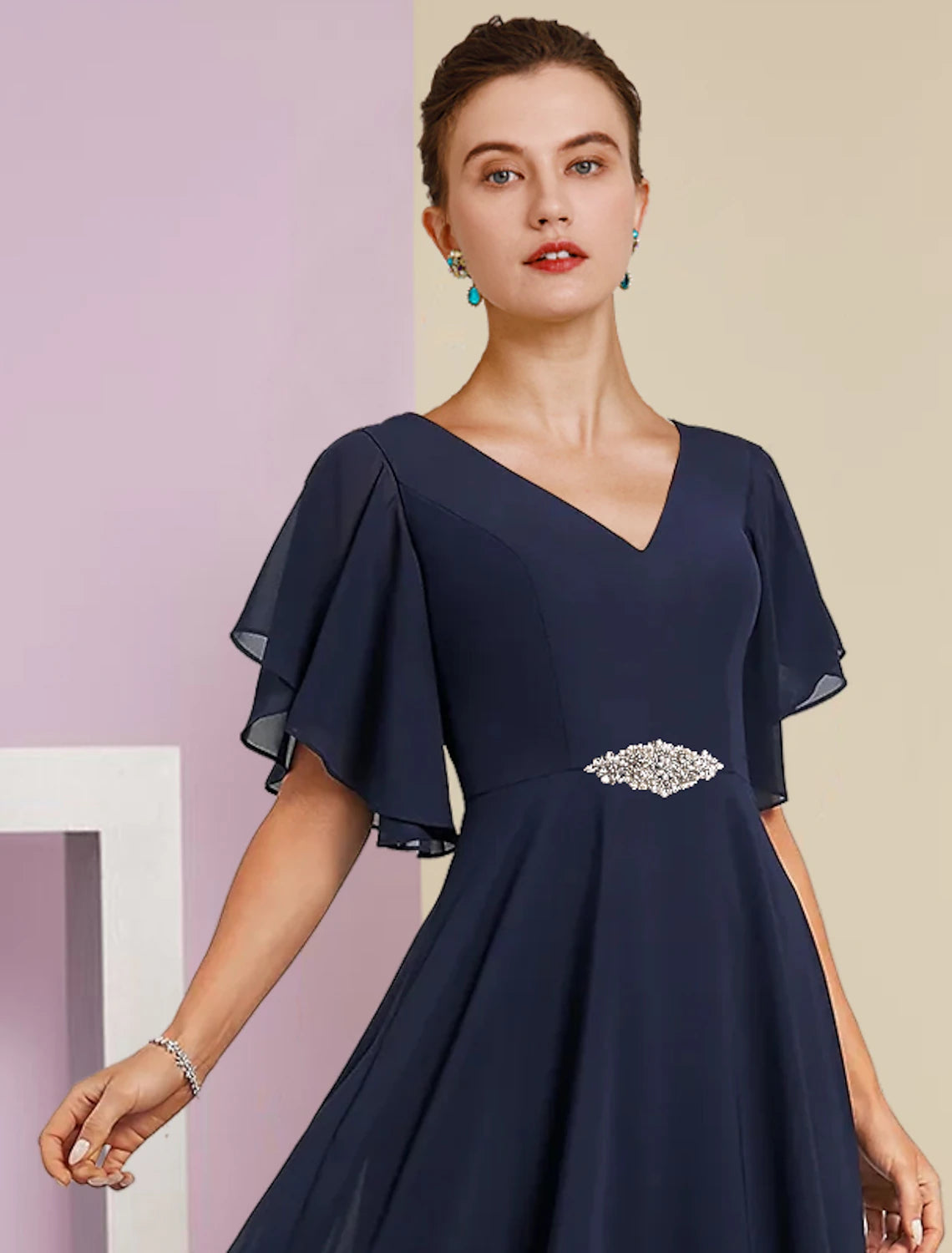 Close-up of the V-neckline and delicate lace appliques on the short sleeve dress.