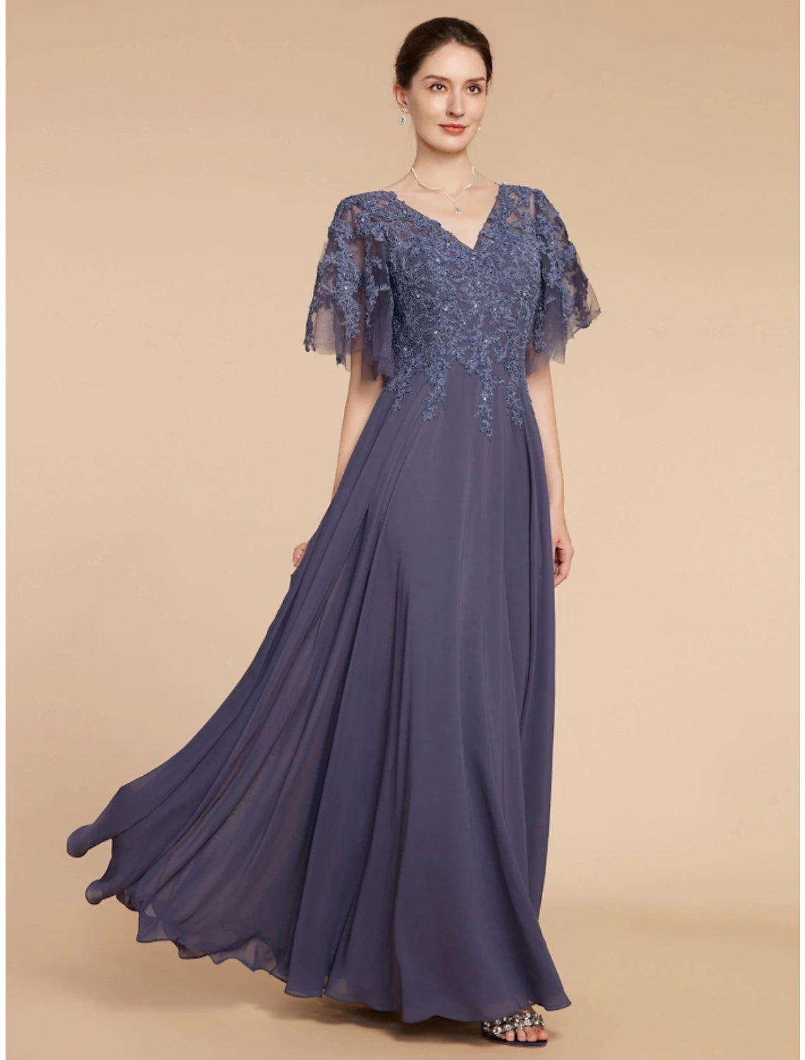 Woman wearing an elegant A-line V-neck short sleeve chiffon lace dress with sequin ruching.