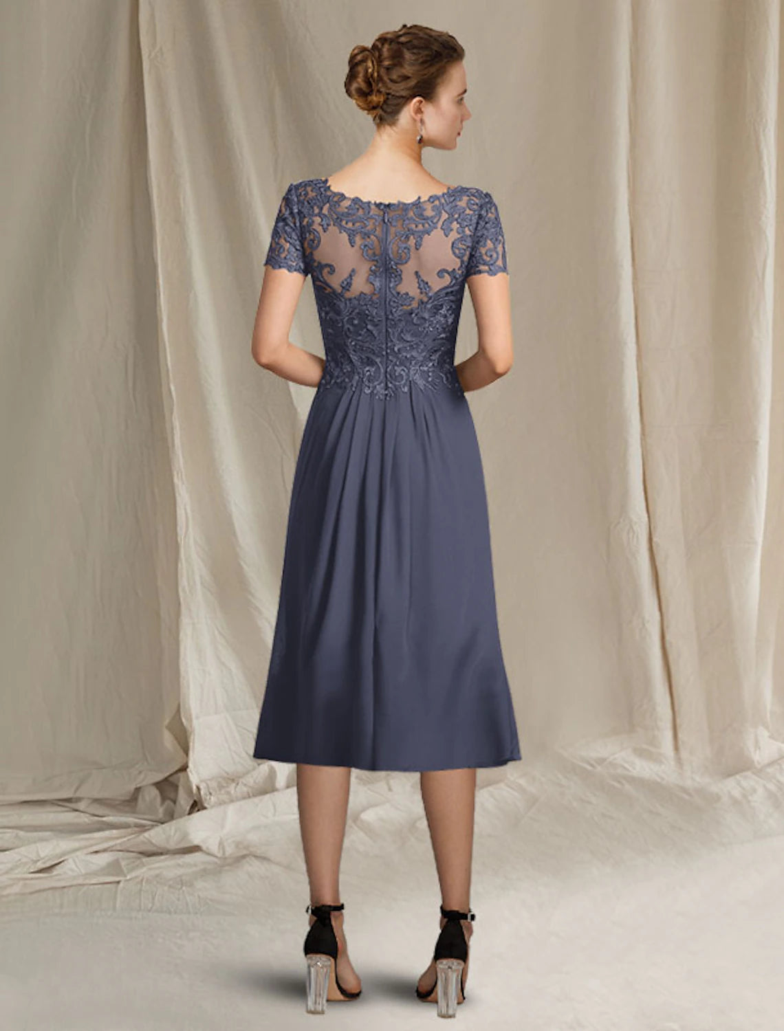 Close-up of the V-neckline and short lace sleeves on the mother of the bride dress.
