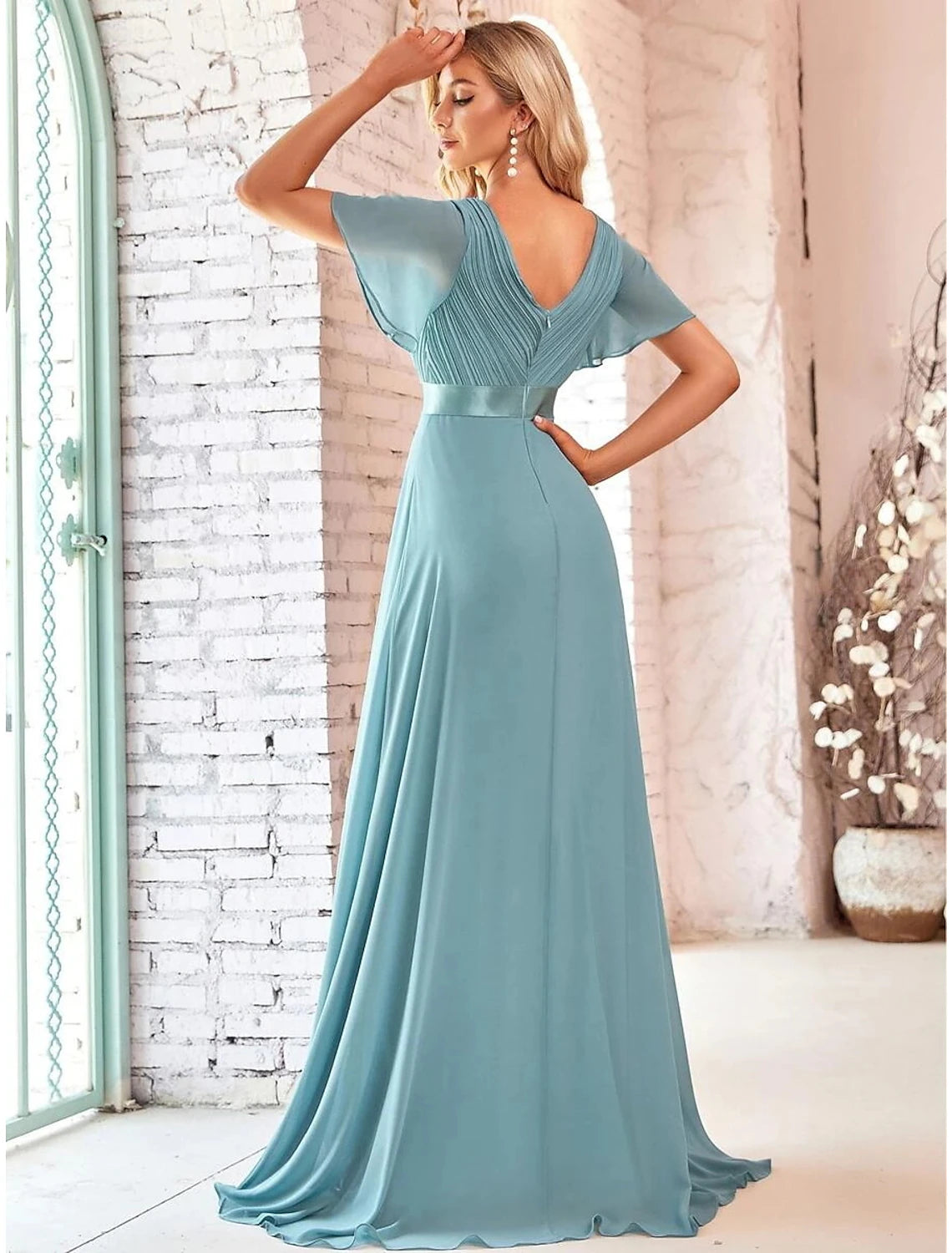 Back view of a woman in an A-line V-neck short sleeve evening gown with ruffles.