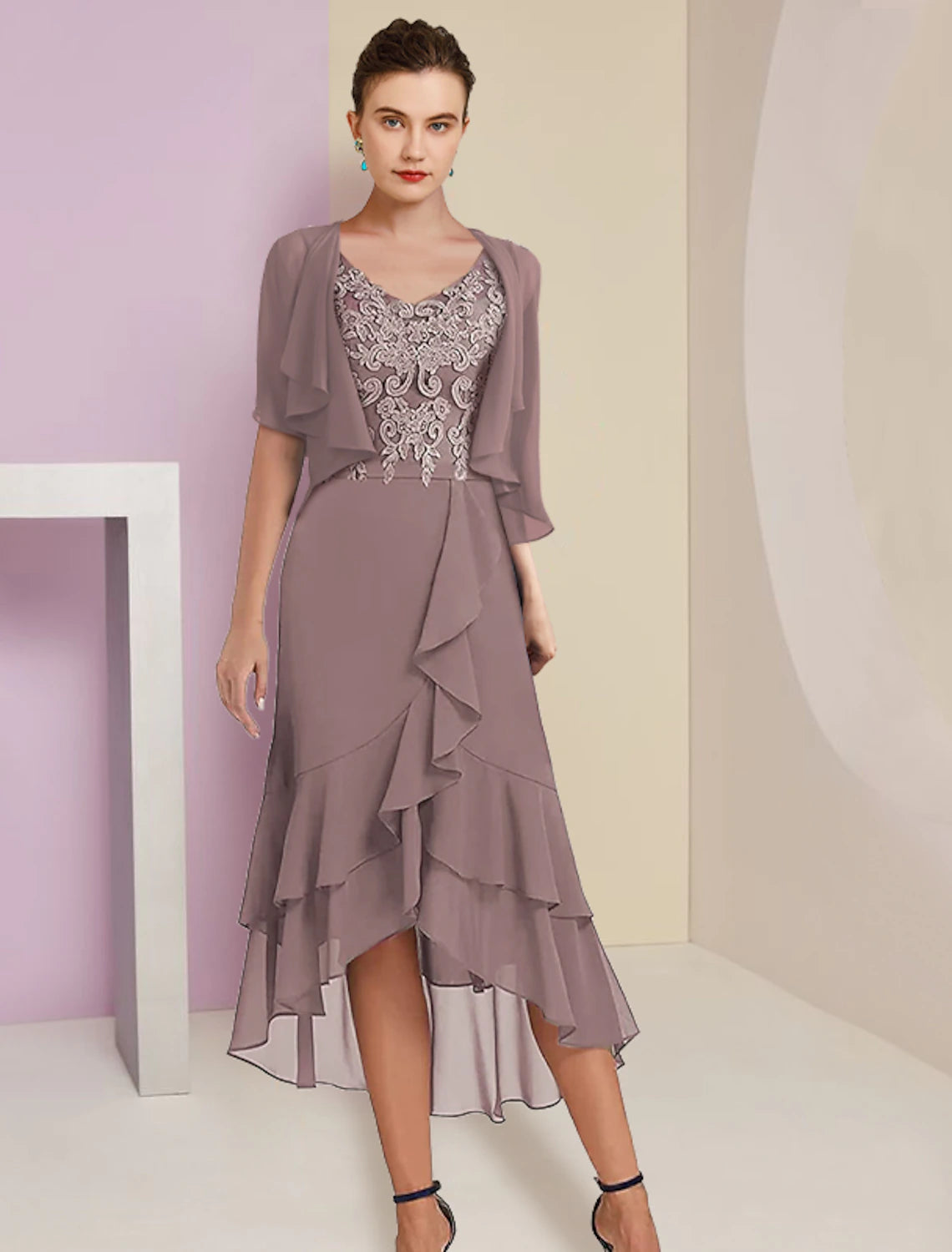 Model wearing elegant A-line V-neck two-piece mother of the bride dress with short sleeves and high-low hem.