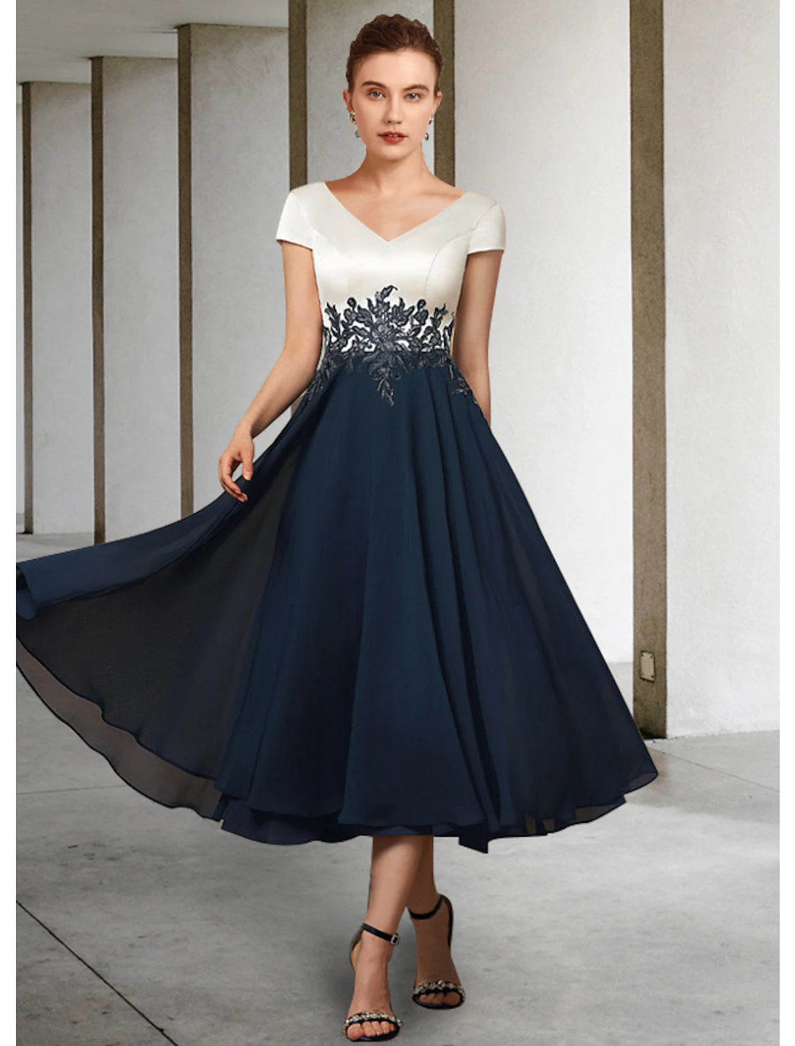Model wearing an elegant Weitese A-line V-neck tea-length mother of the bride dress with short sleeves and lace appliques.