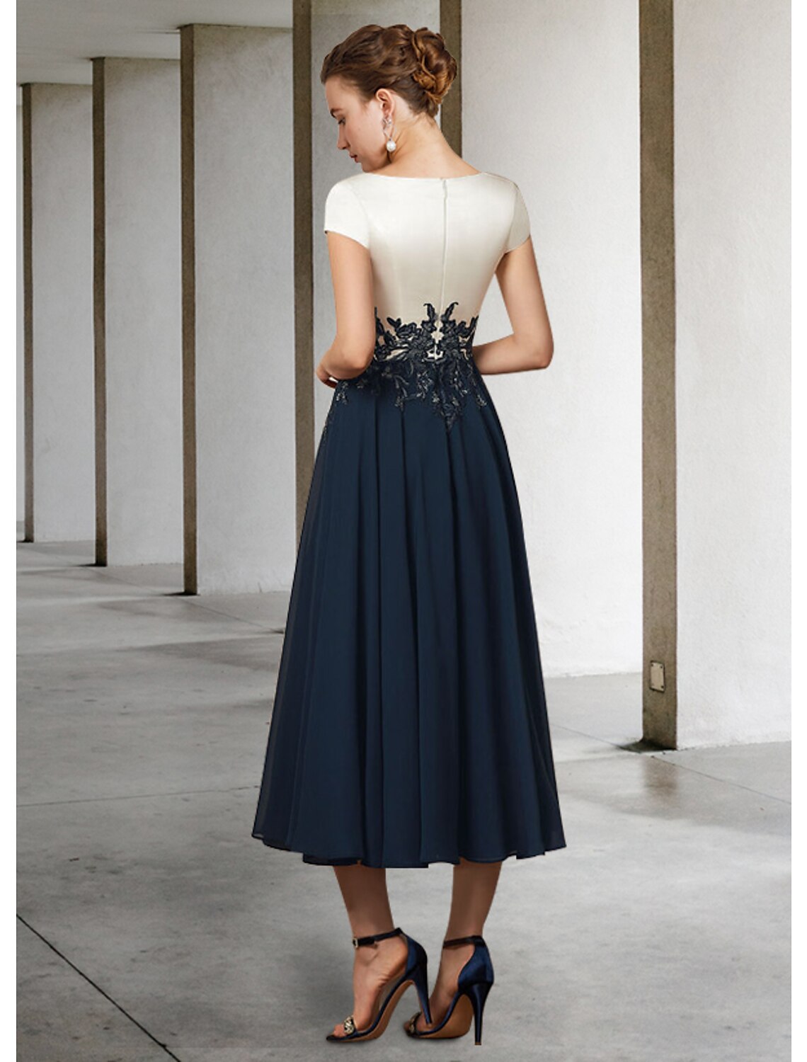 Close-up of the V-neckline and short lace sleeves on the Weitese mother of the bride dress.