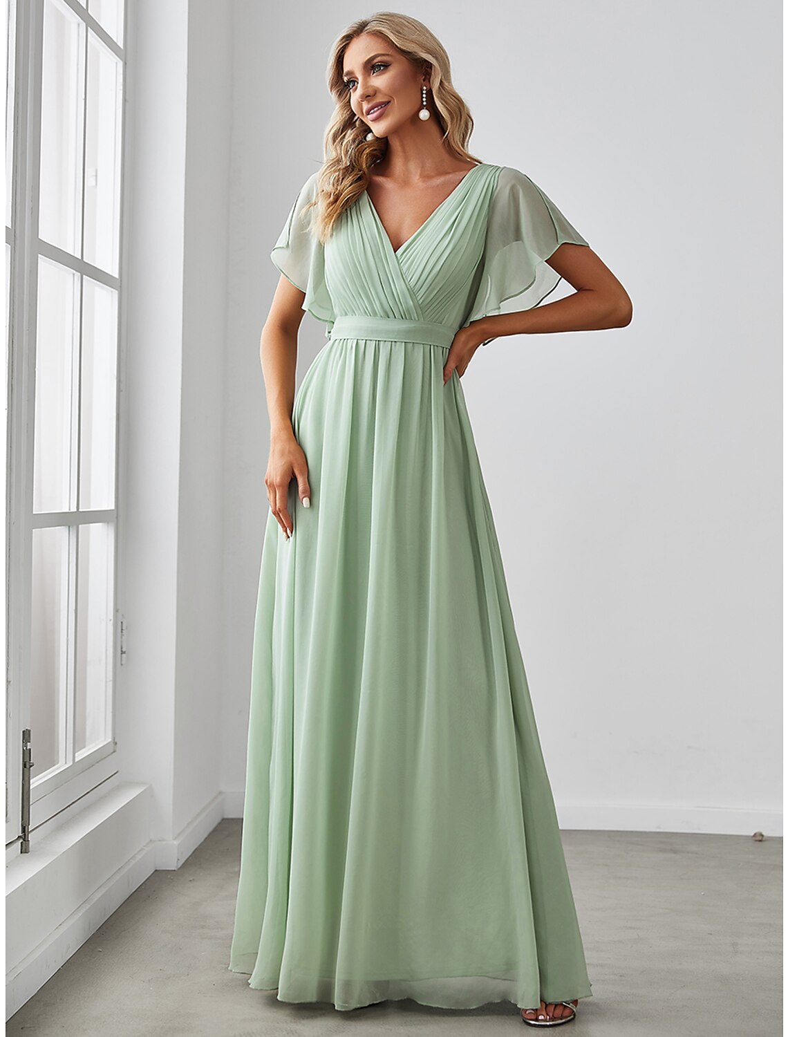 Model wearing a solid color A-line V-neck short sleeve ruffled chiffon bridesmaid dress.