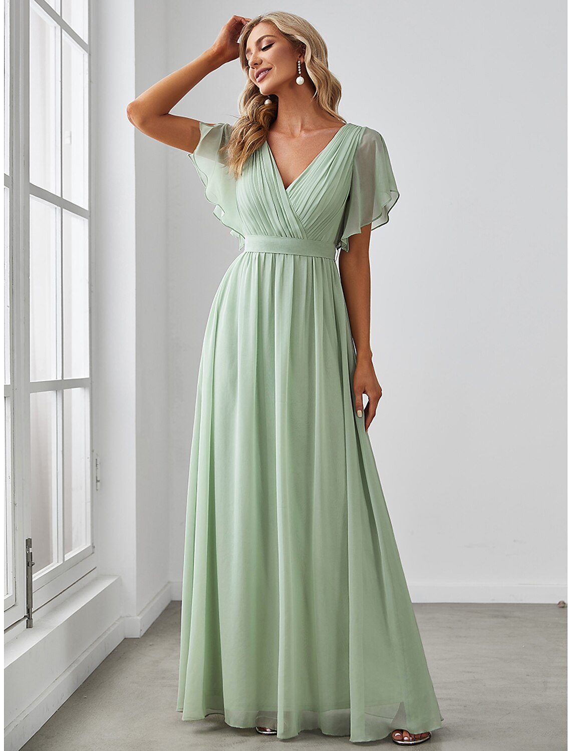 Close-up of the ruffled short sleeve and V-neckline of the chiffon bridesmaid dress.