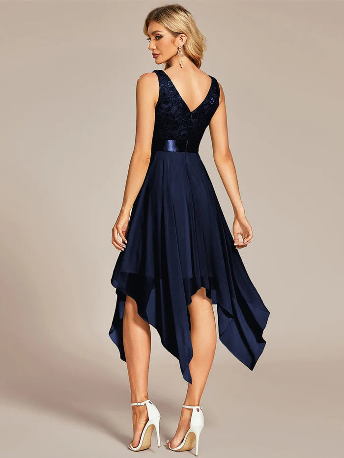 Side view of a woman in a blue V-neck lace dress with an asymmetrical hem.