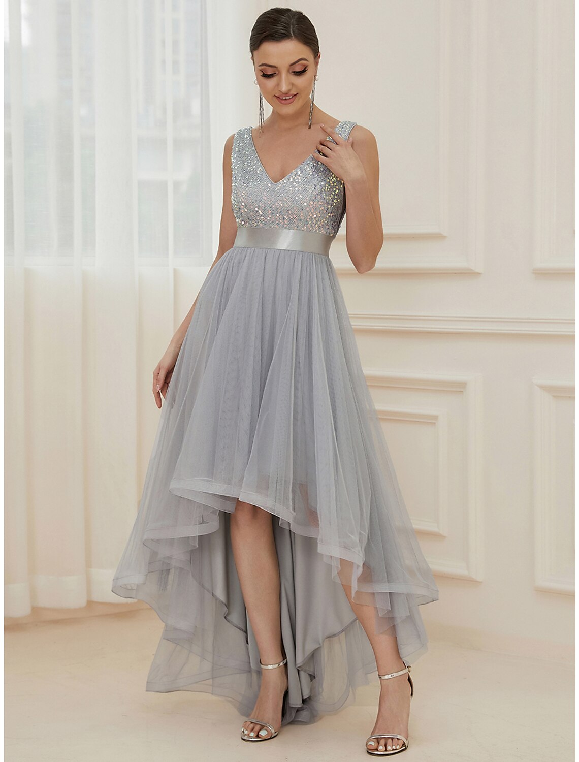Full-length view of a woman wearing the sequined asymmetrical A-line bridesmaid dress.