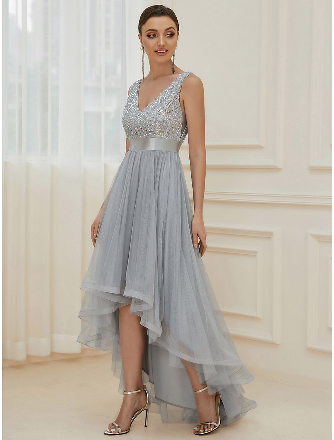 Close-up of the sequined fabric and asymmetrical hemline of the bridesmaid dress.