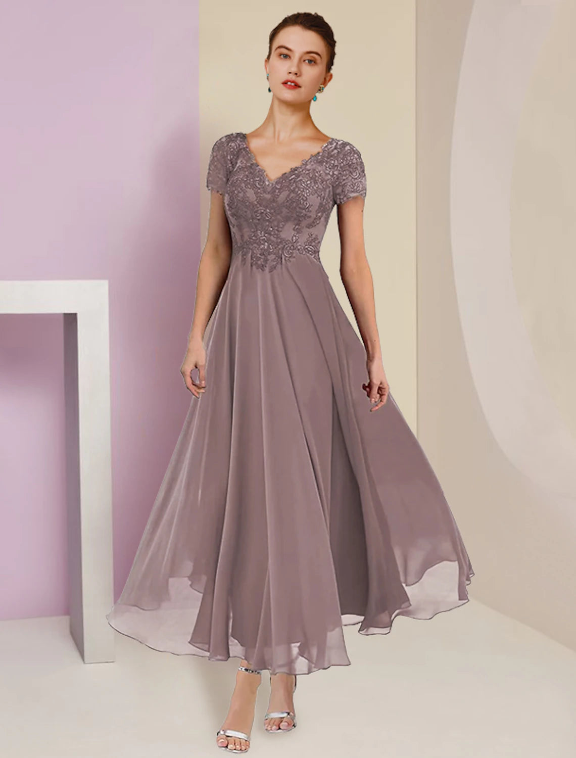 Model wearing an elegant two-piece A-line V-neck tea length mother of the bride dress with a short sleeve jacket.