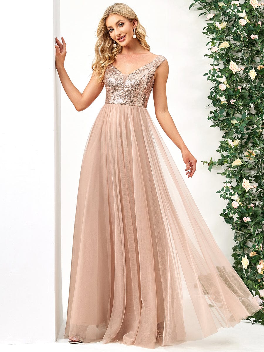 Back view of a model in a rose gold A-line sequin off-shoulder maxi tulle dress.