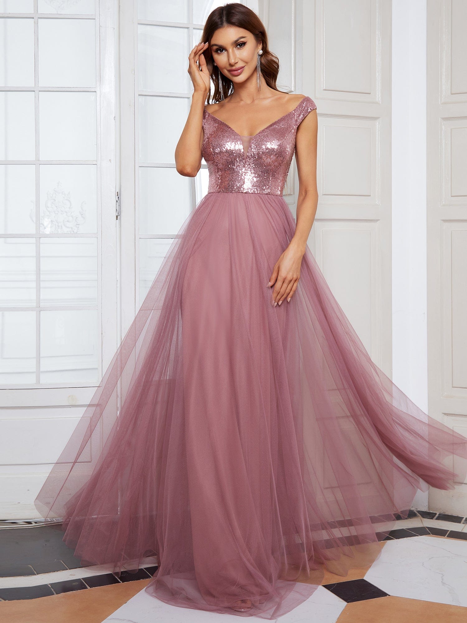 Model wearing an olive green A-line sequin off-shoulder maxi tulle dress.