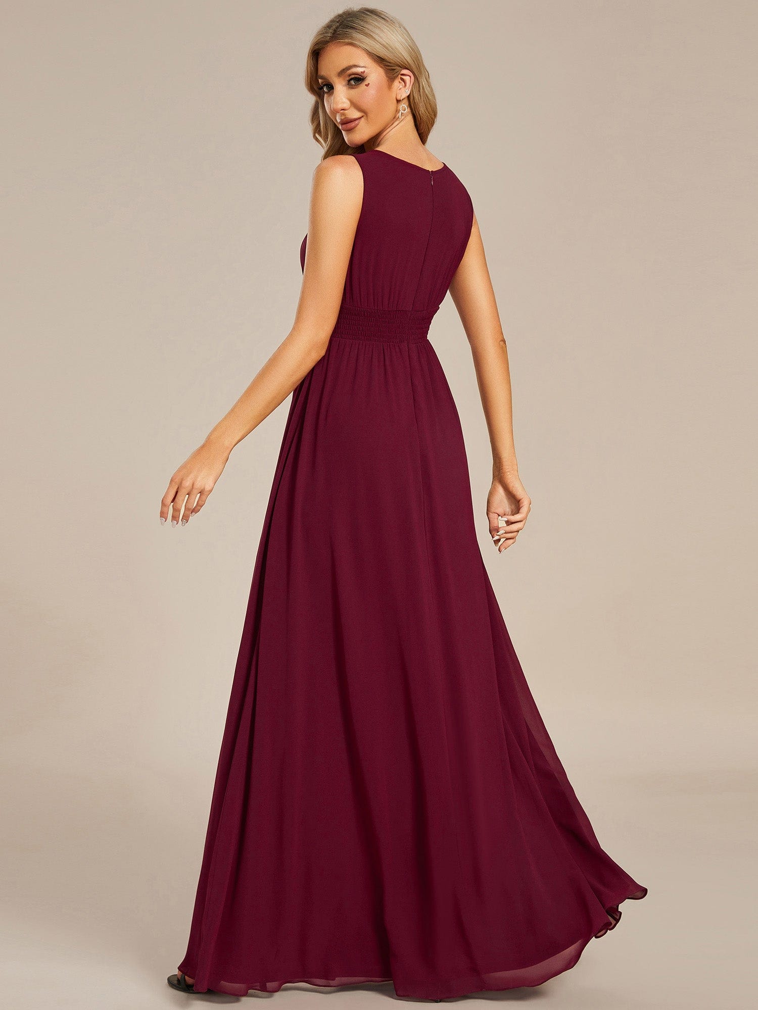 Side view of a model in a red A-line sleeveless chiffon bridesmaid dress.