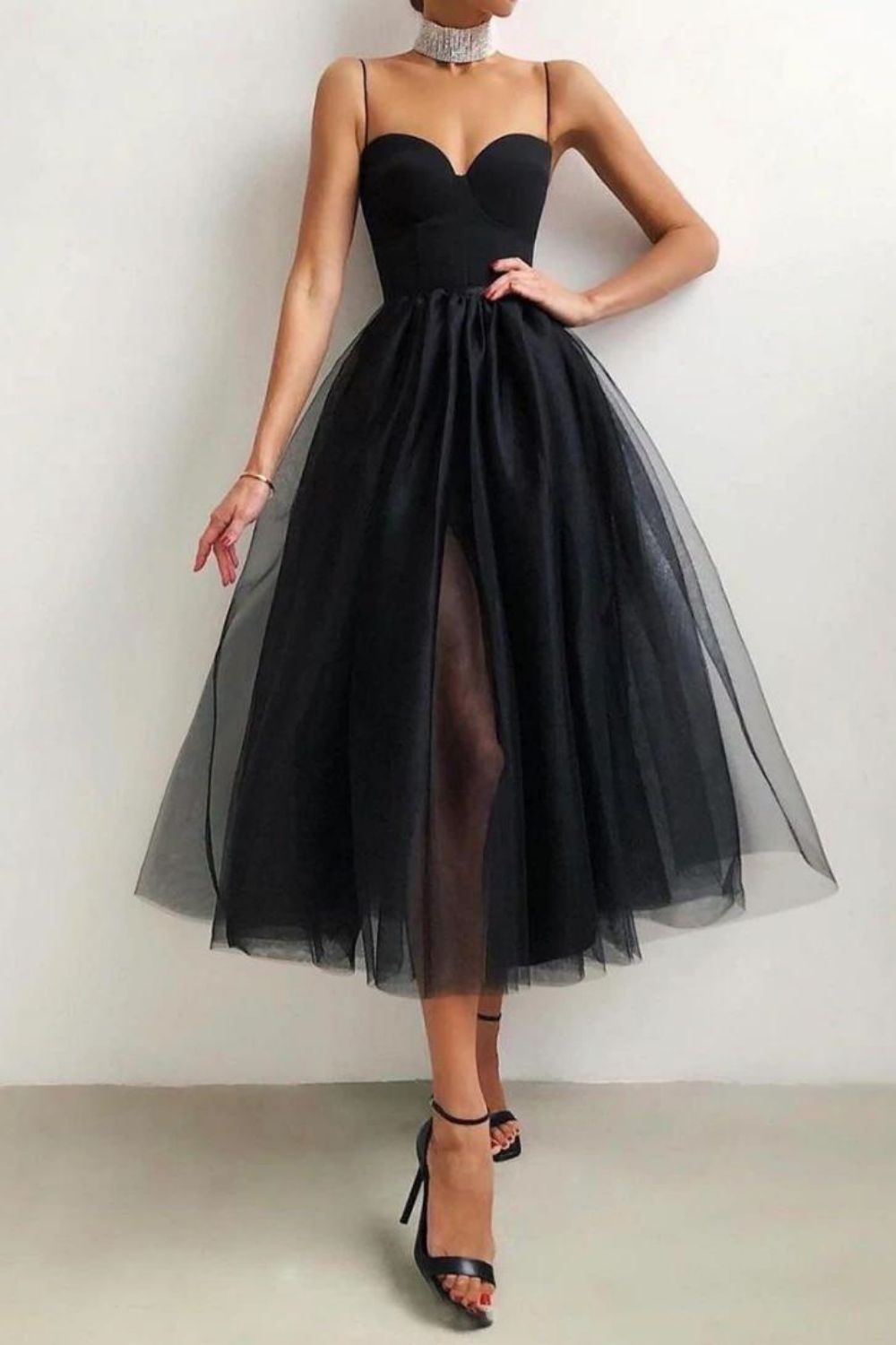 Model wearing a black A-line spaghetti strap party dress.