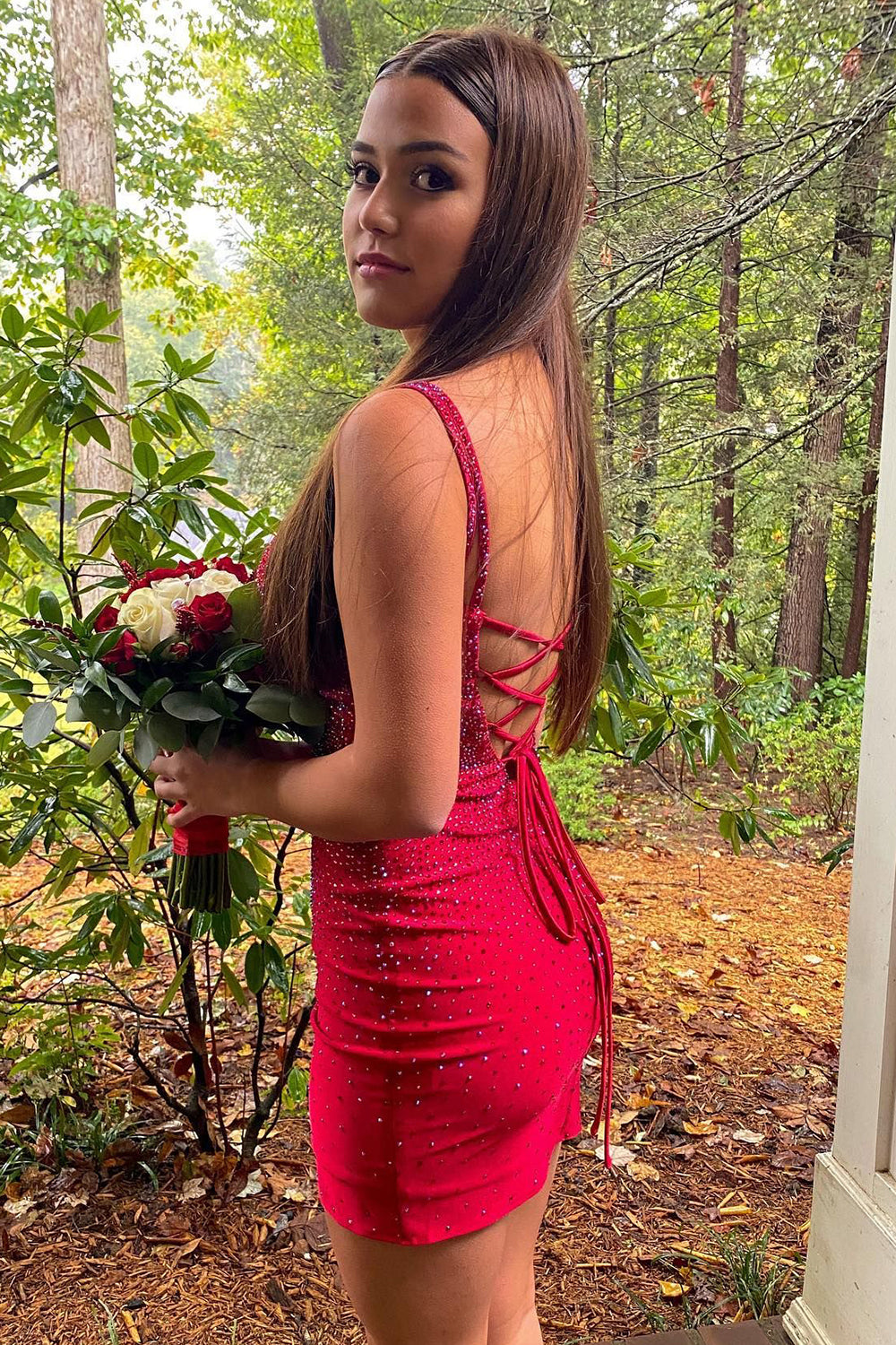 Back view of a red sheath homecoming dress with spaghetti straps and beading.