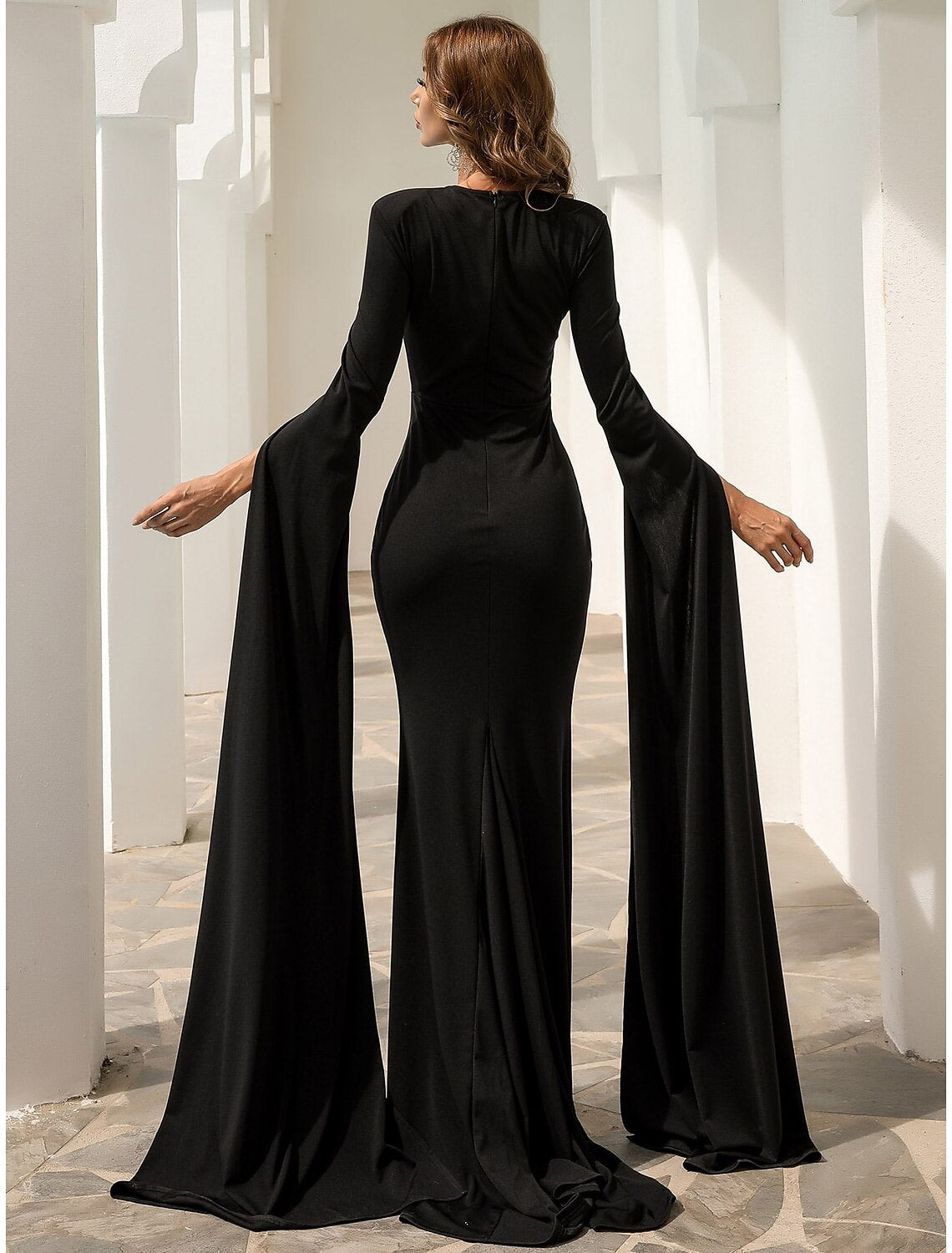 Side profile of the black mermaid trumpet gown, highlighting the court train and pleats.