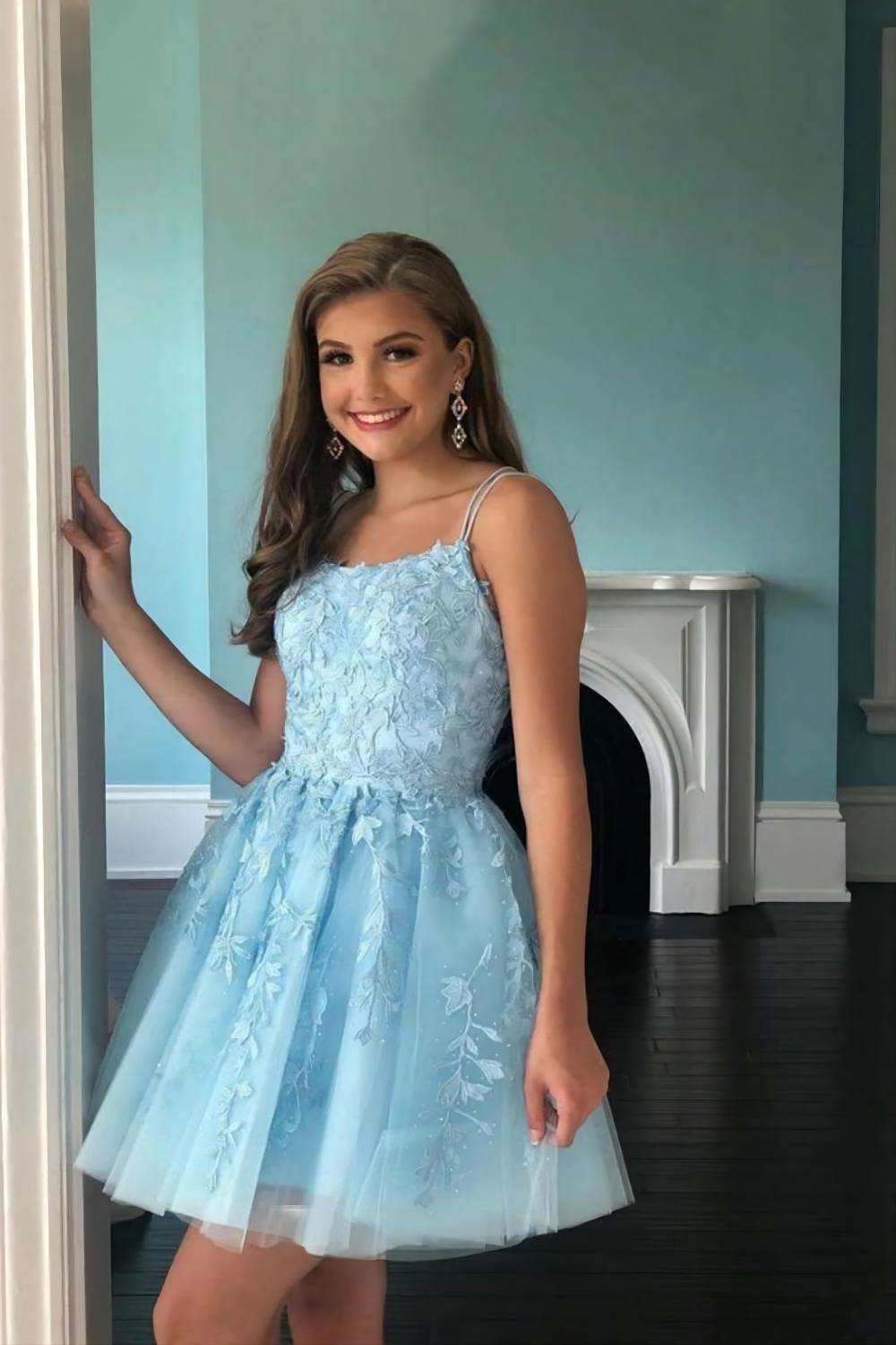 Model wearing a blue A-line homecoming dress with corset back and floral applique.