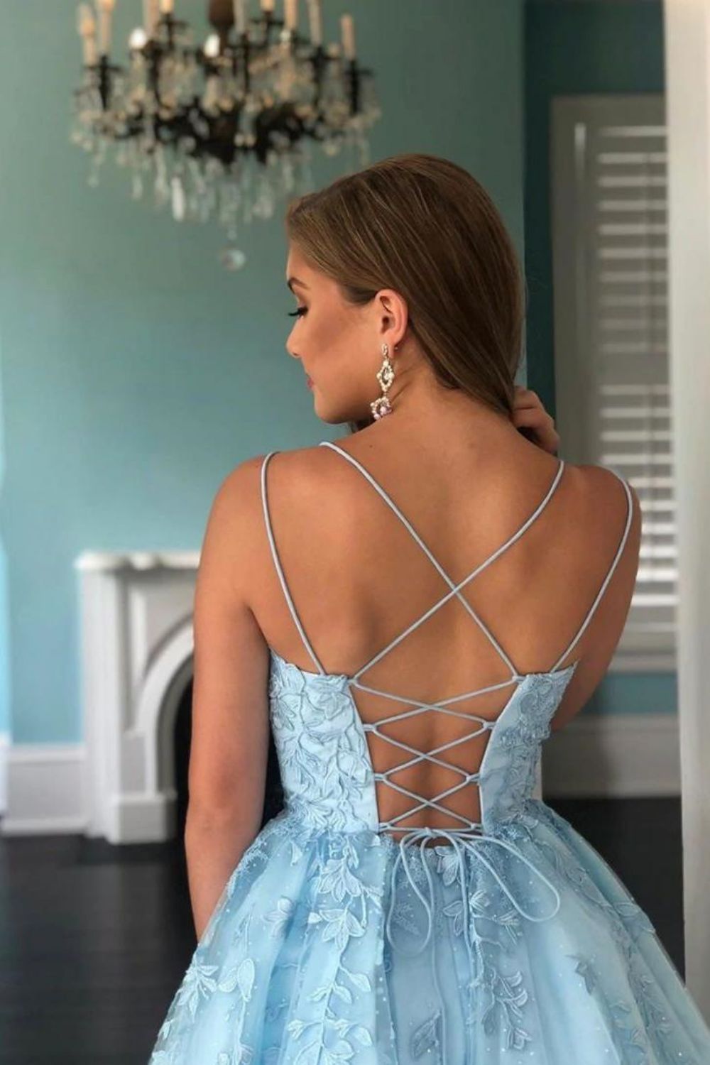 Back view of the blue A-line dress showing corset lacing and applique details.