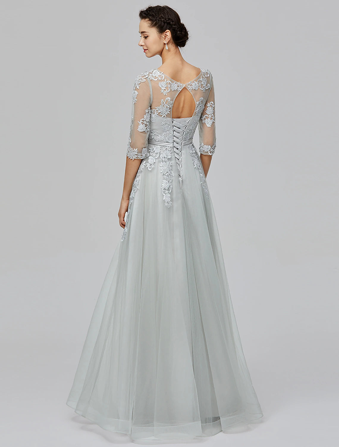 Back view of a blush A-line empire gown featuring delicate appliques and bows.