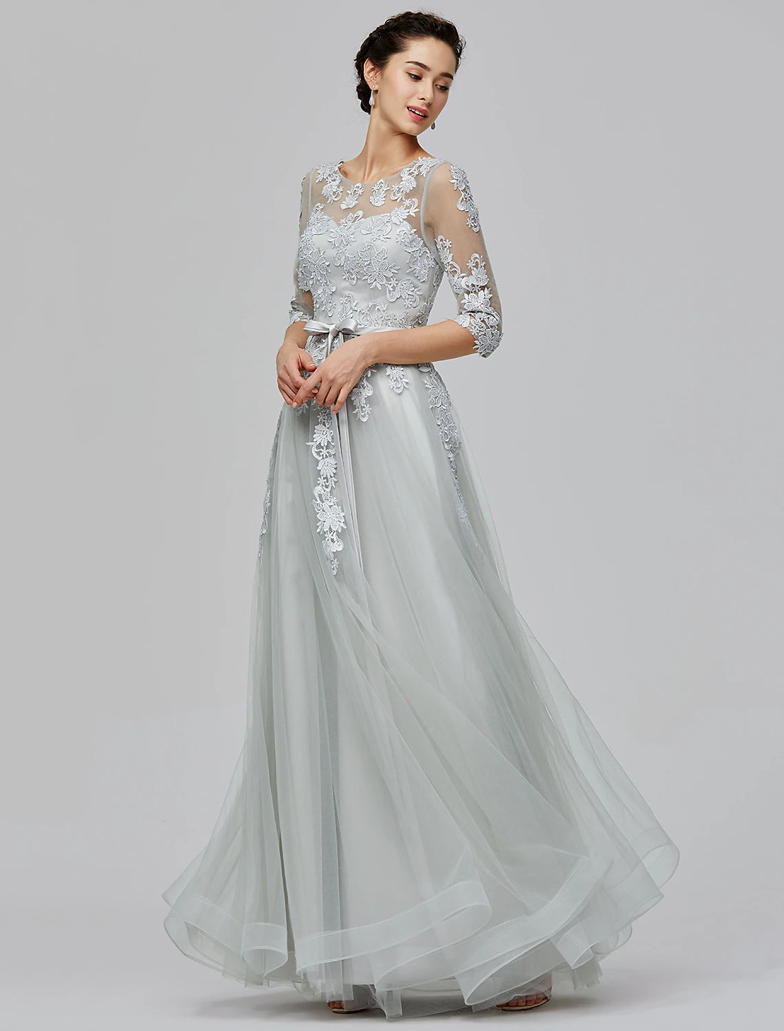 Side profile of a woman wearing a blush A-line empire formal dress.
