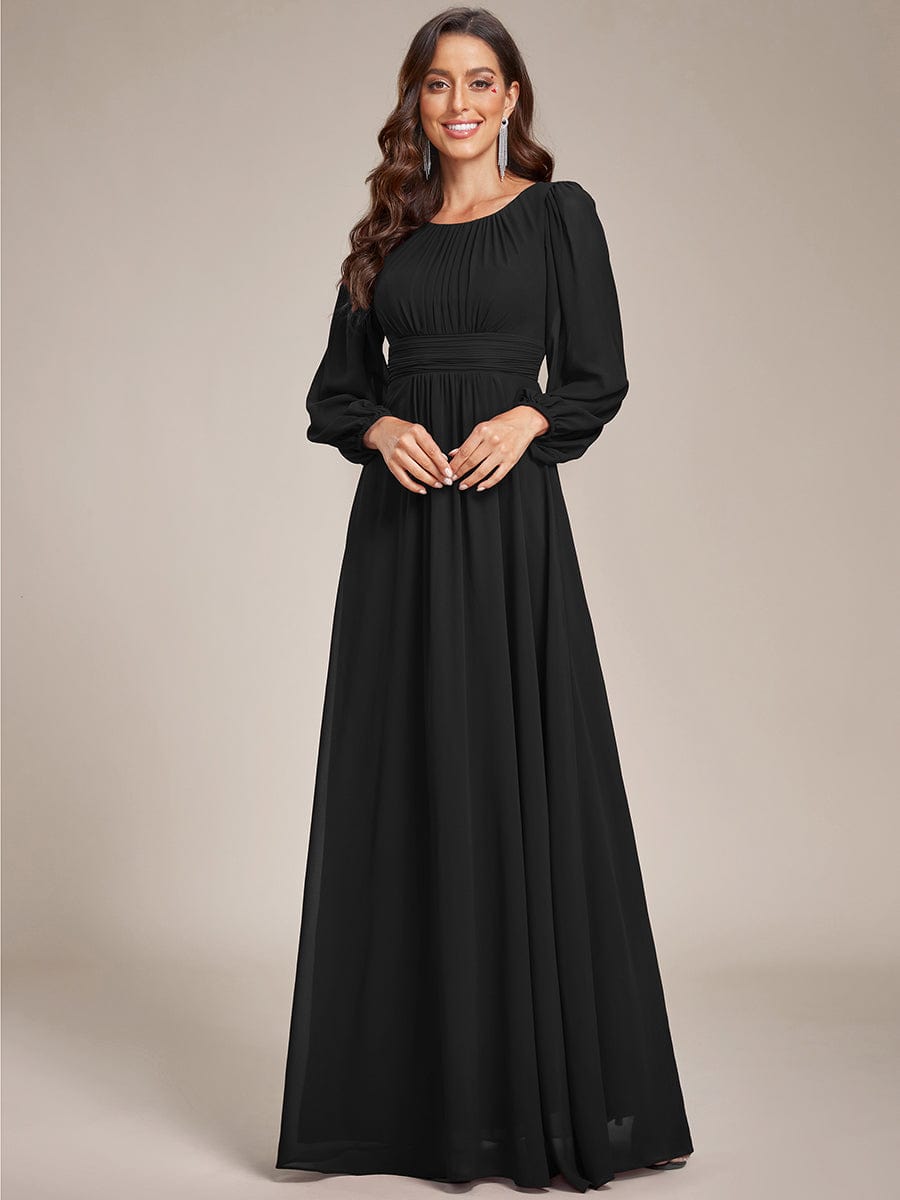 Woman wearing a black Weitese chiffon high empire waist puff sleeve maxi dress.
