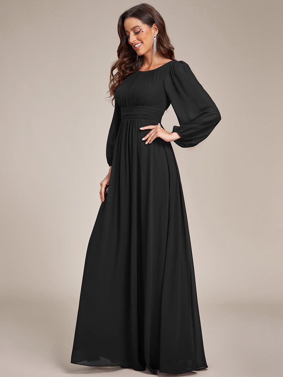 Woman posing in a black Weitese chiffon puff sleeve formal dress.