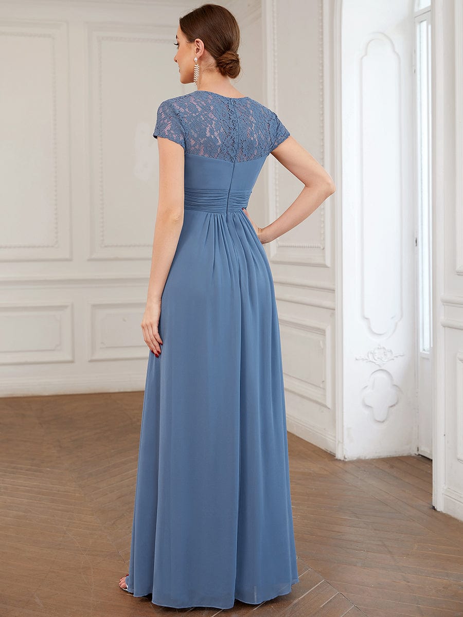Side view of a model in a dark chiffon A-line bridesmaid dress with ruched bodice.