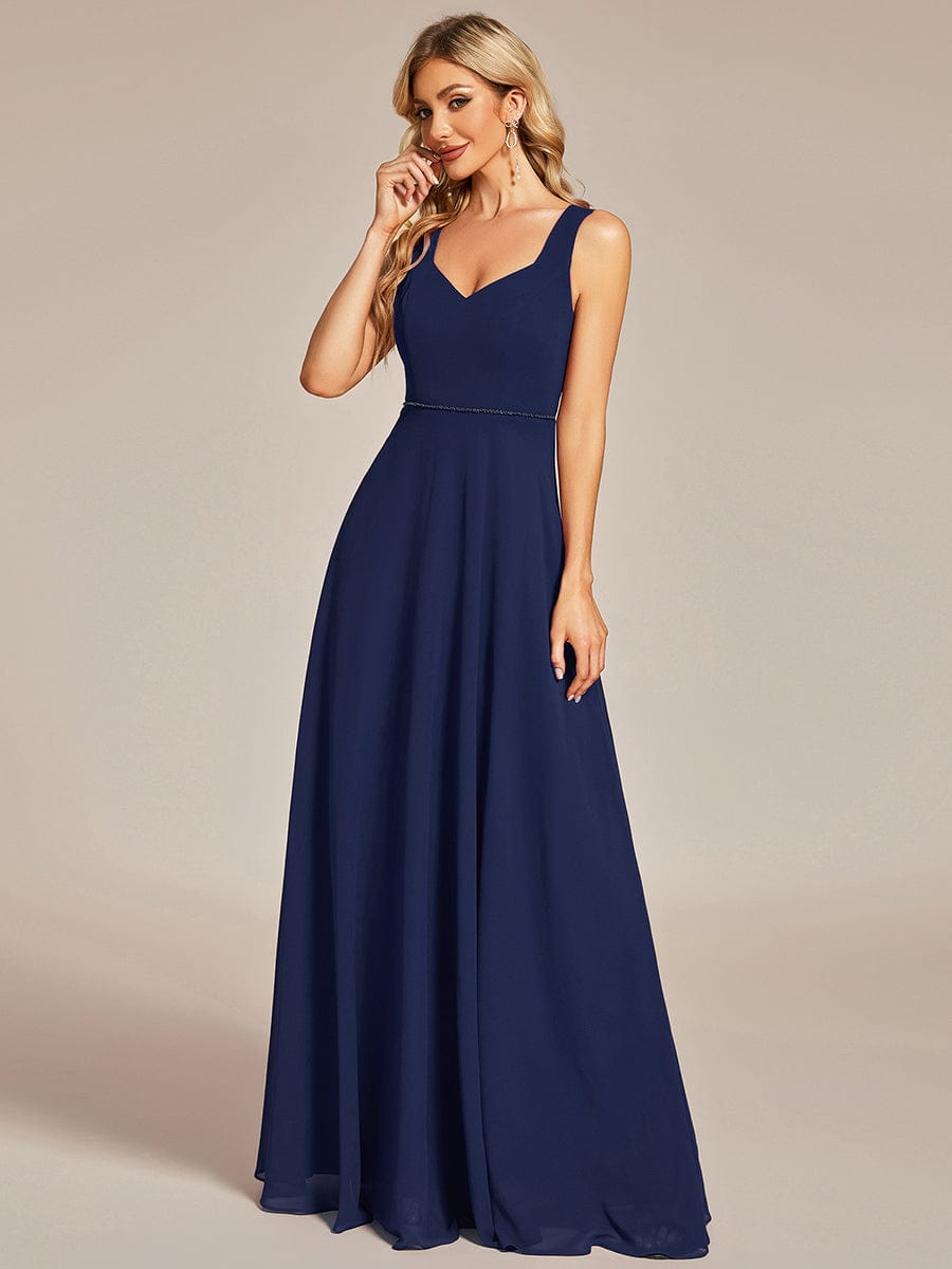 Back view of a navy blue chiffon dress with hollow out detail.
