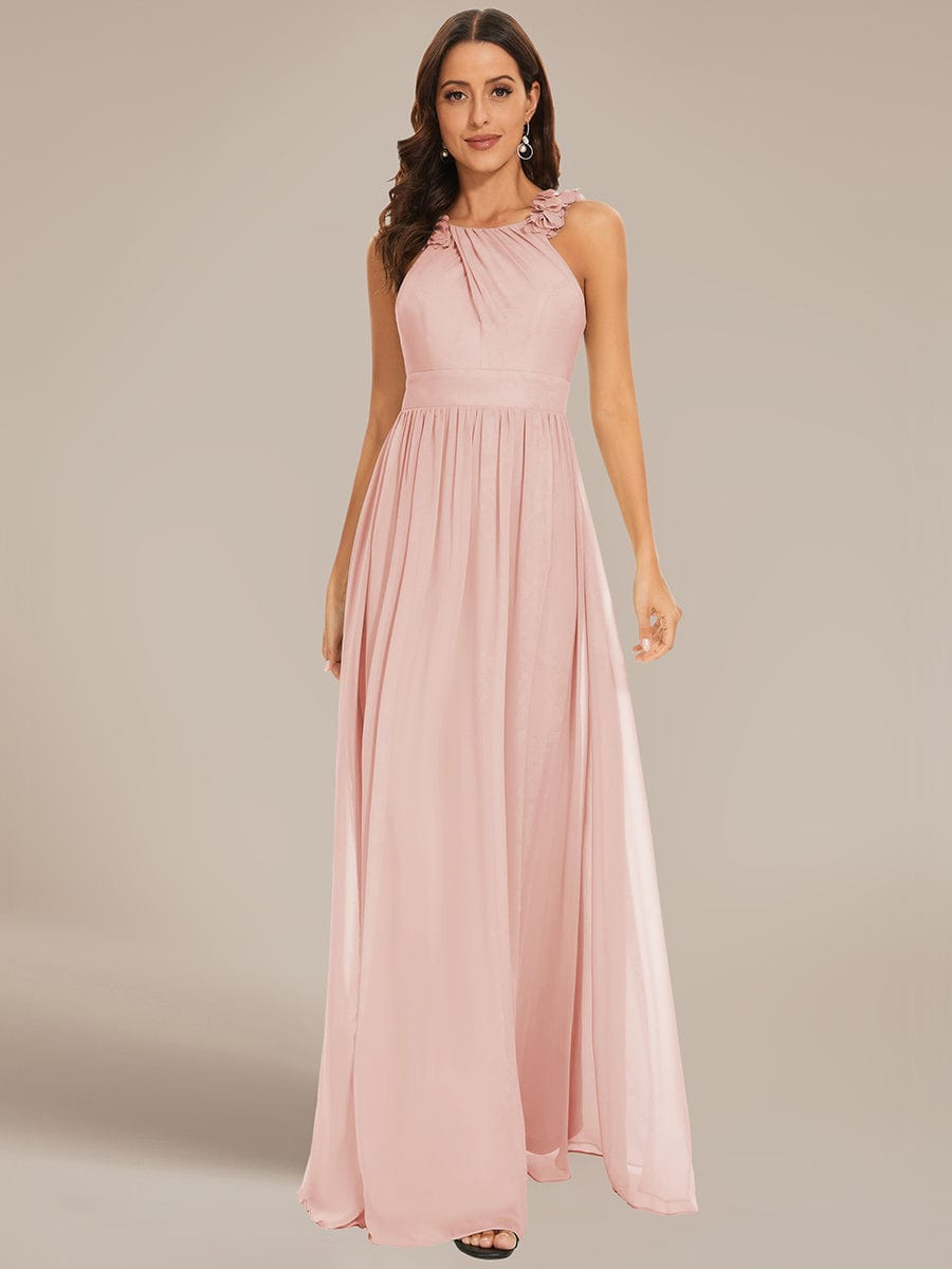Side view of model wearing pink floral applique pleated chiffon dress.