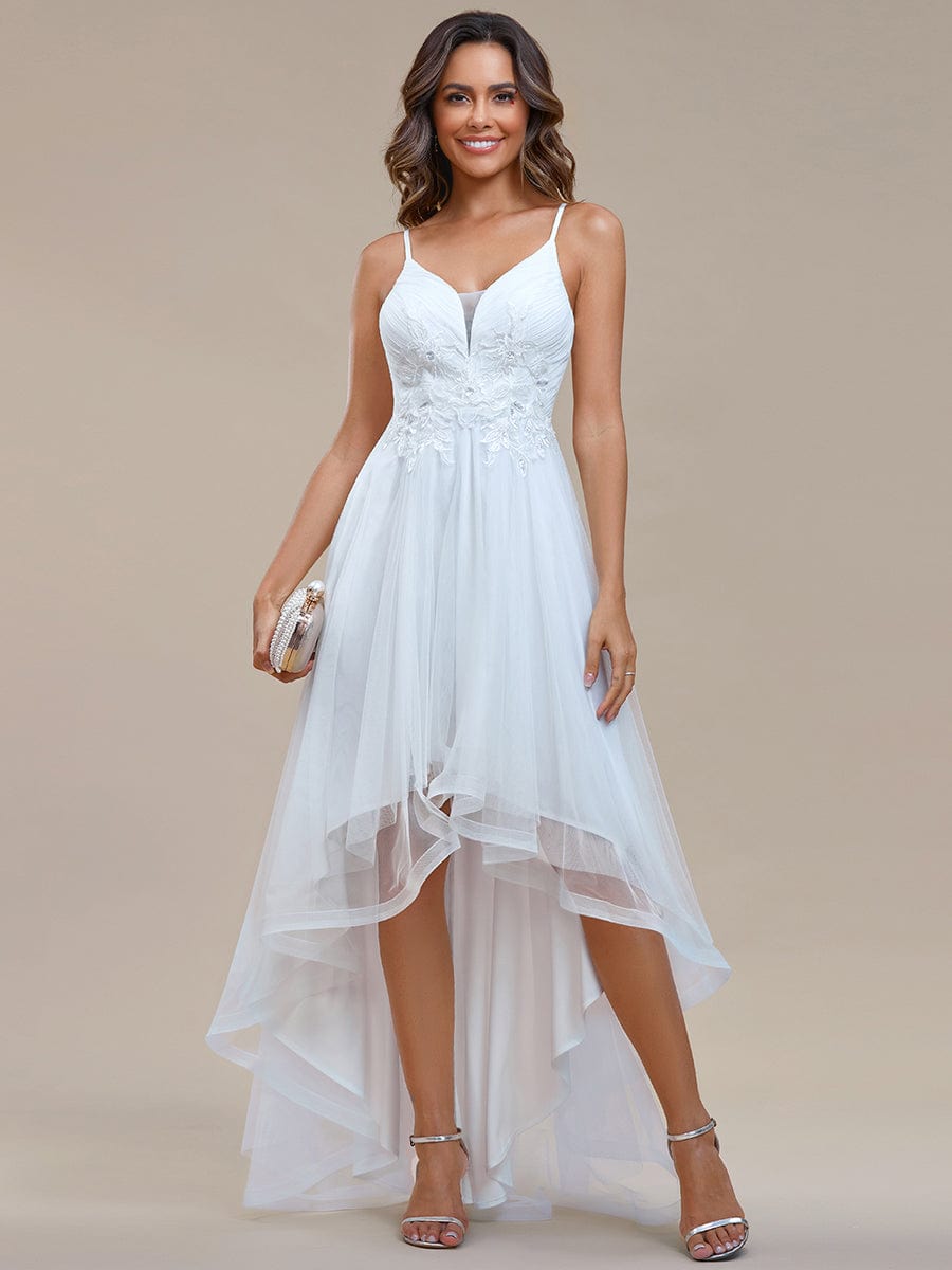 White floral embroidered high-low prom dress on a model.