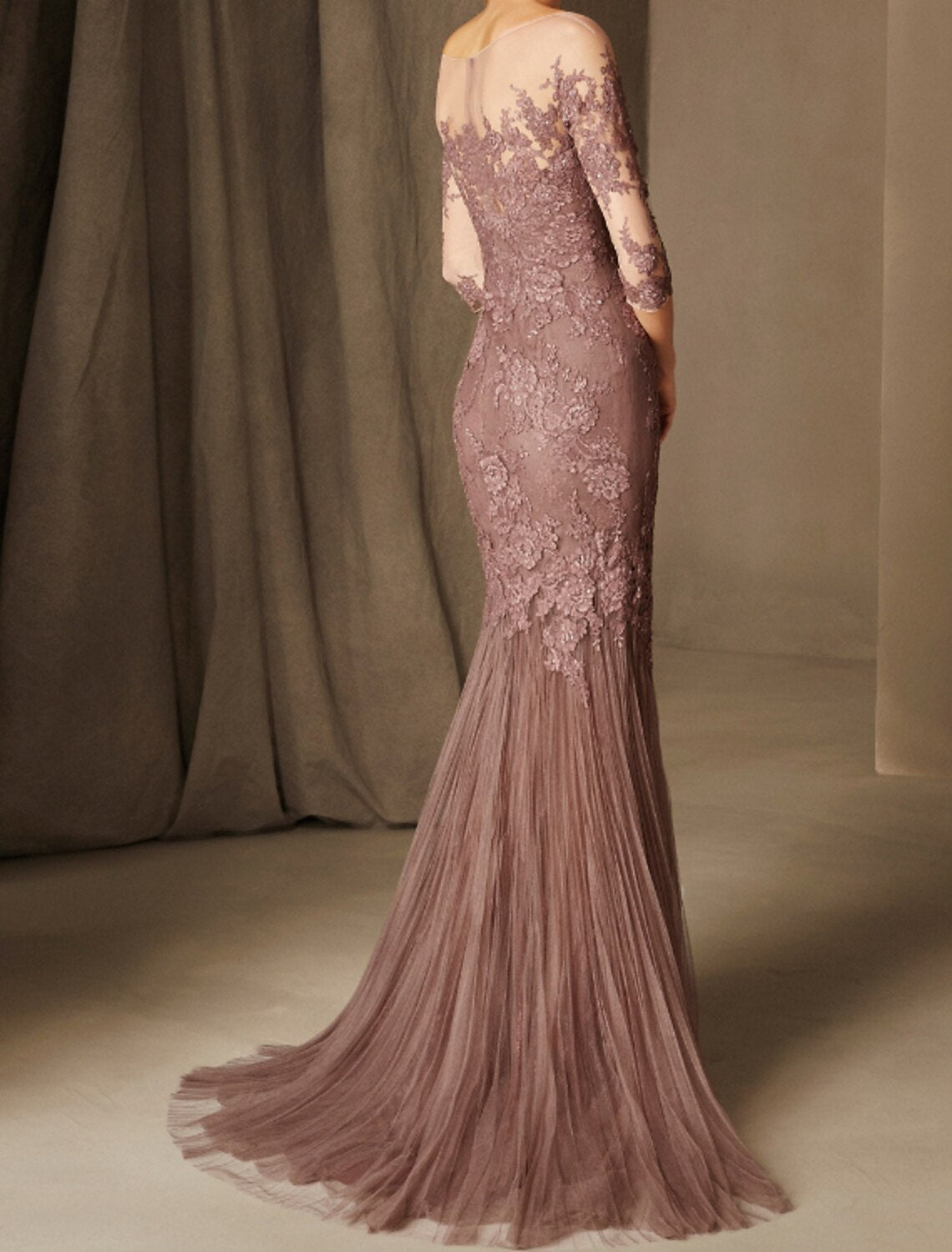 Woman in a floral mermaid evening dress, showing the sweep train and side profile.