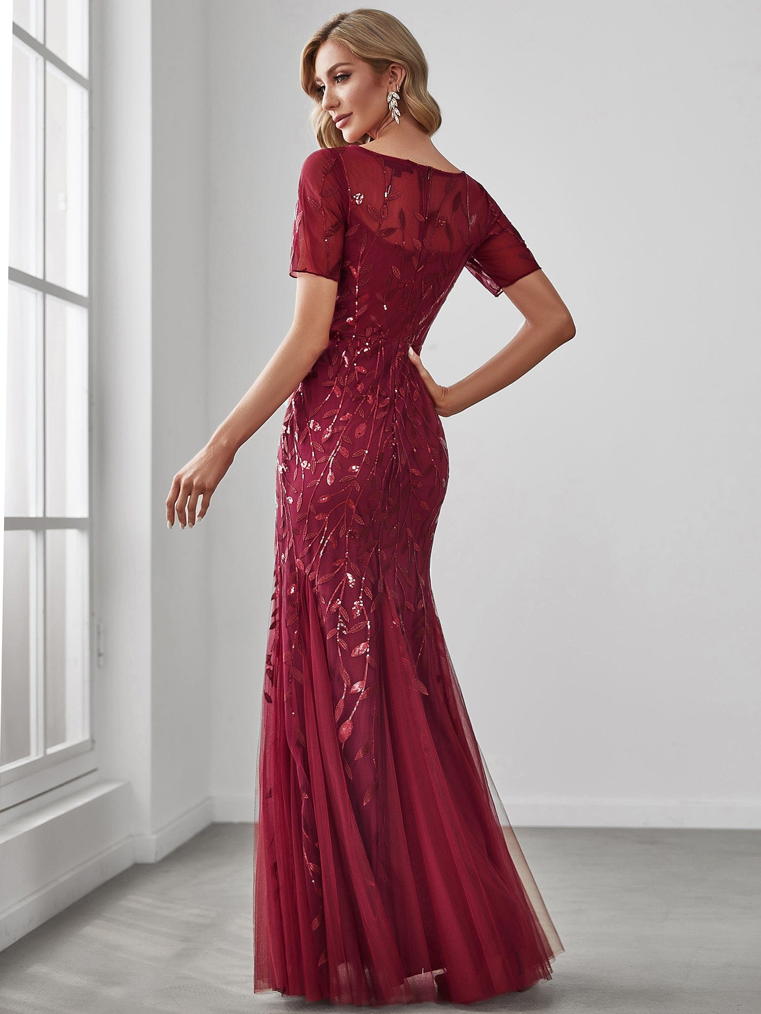 Side view of the elegant floral sequin maxi dress, showing fishtail silhouette.