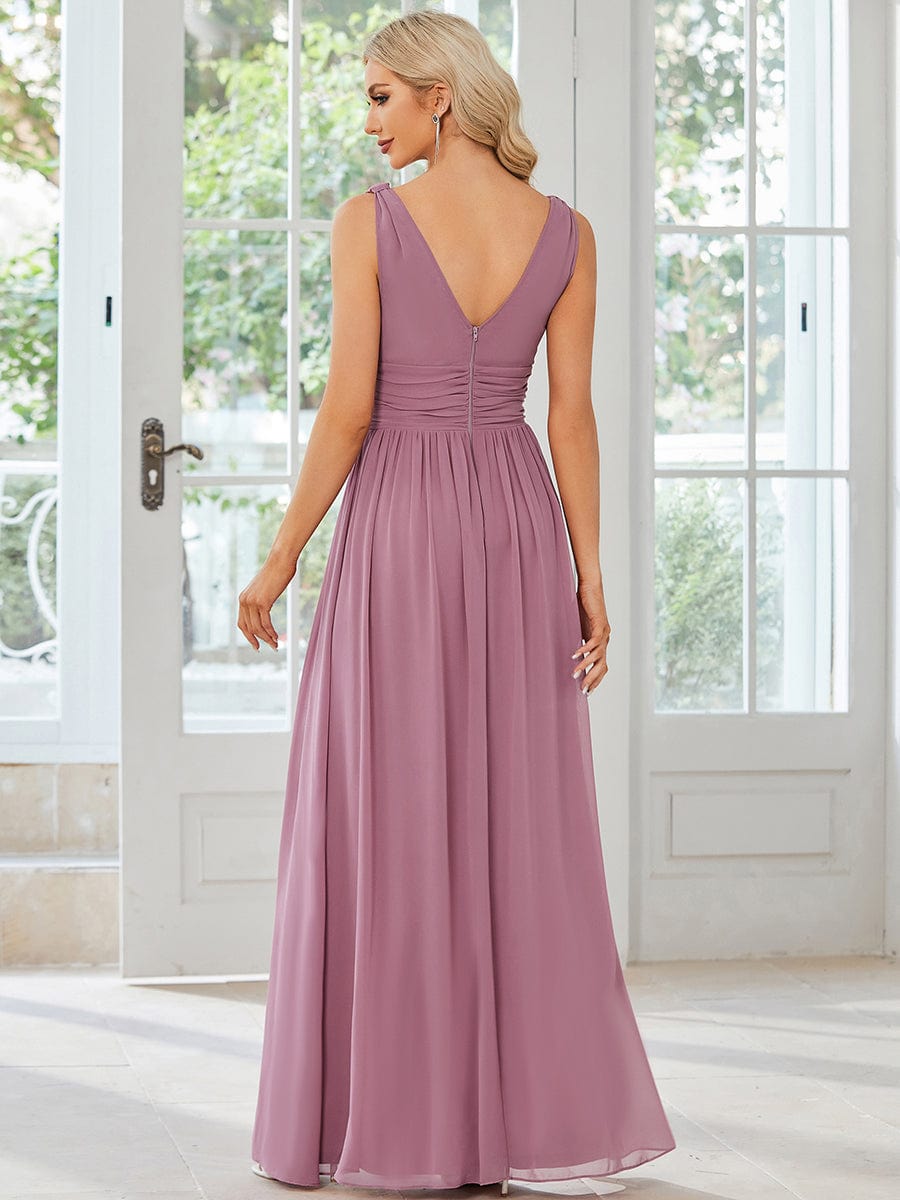 Side view of a model in an elegant sleeveless bridesmaid dress.