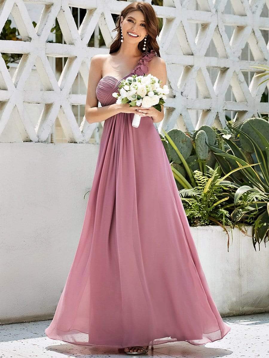 Woman posing in a sophisticated burgundy one-shoulder maxi chiffon gown.