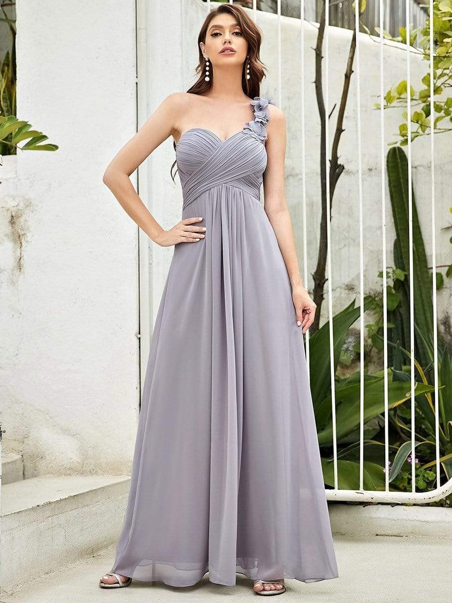 Woman showcasing a stylish grey one-shoulder maxi chiffon bridesmaid dress.