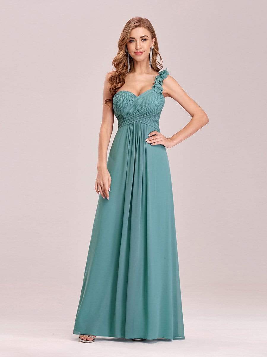 Woman wearing a deep blue one-shoulder maxi chiffon evening gown.