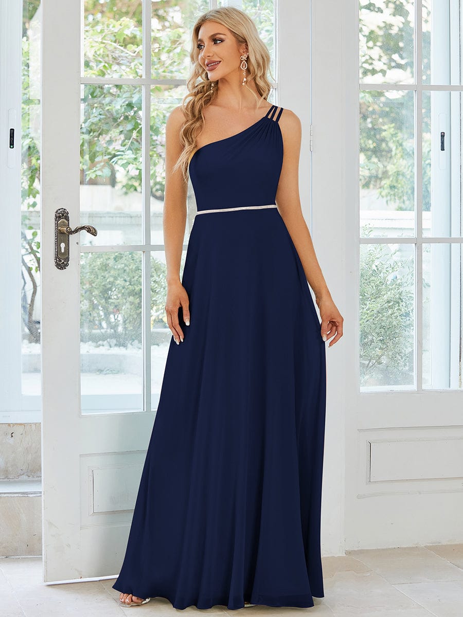 Model wearing a navy blue flowy chiffon one-shoulder bridesmaid dress.